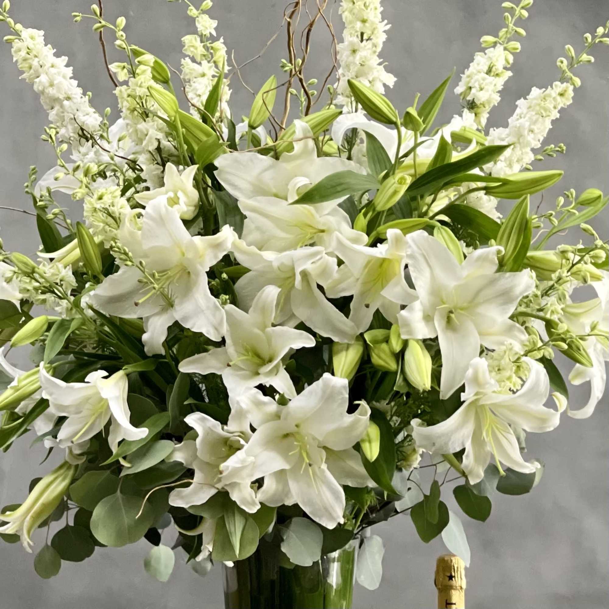 This Display of over 20 Stems of Crystal White Lily&#039;s accented with