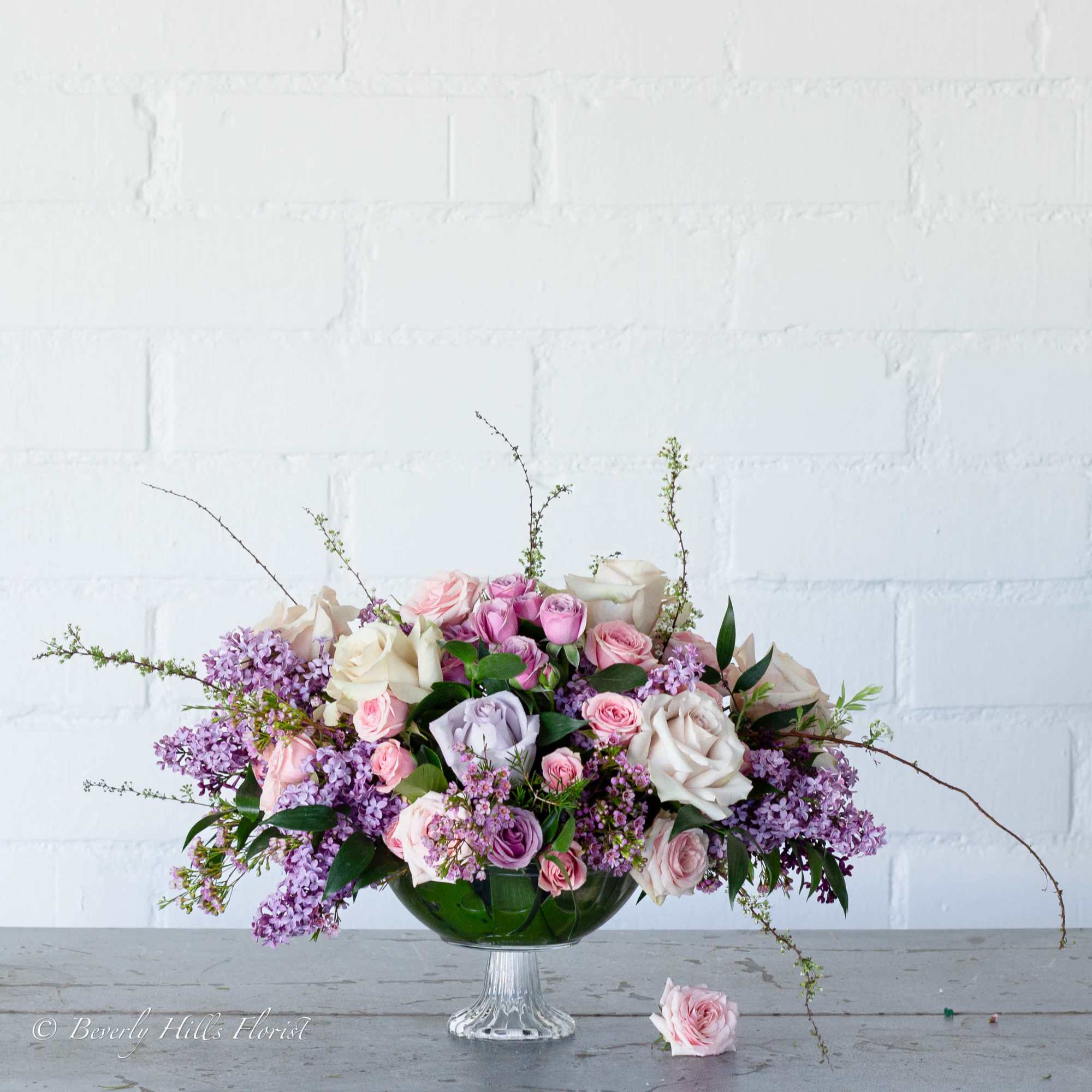 A beautiful floral arrangement featuring local lilacs and soft-colored roses set in