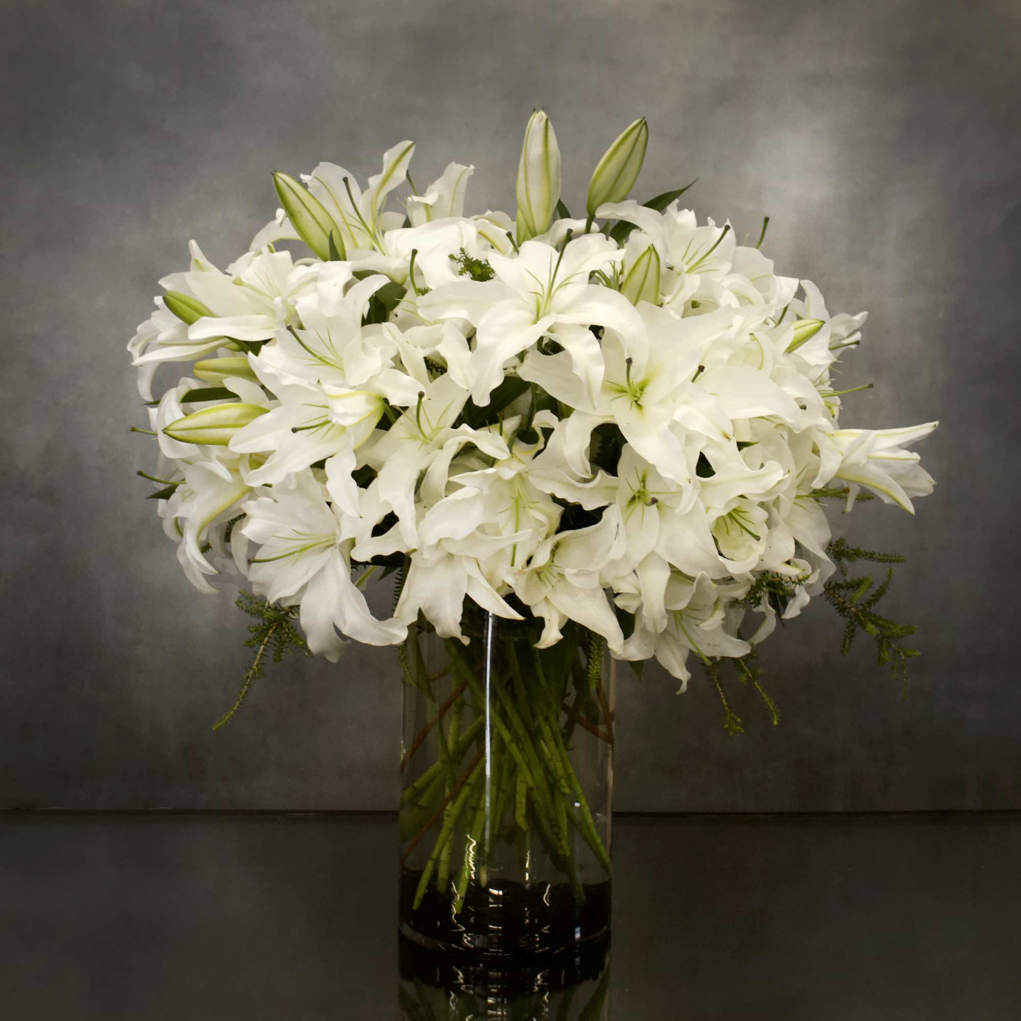 The design features white Casablanca lillies in a vase AS SHOWN PREMIUM