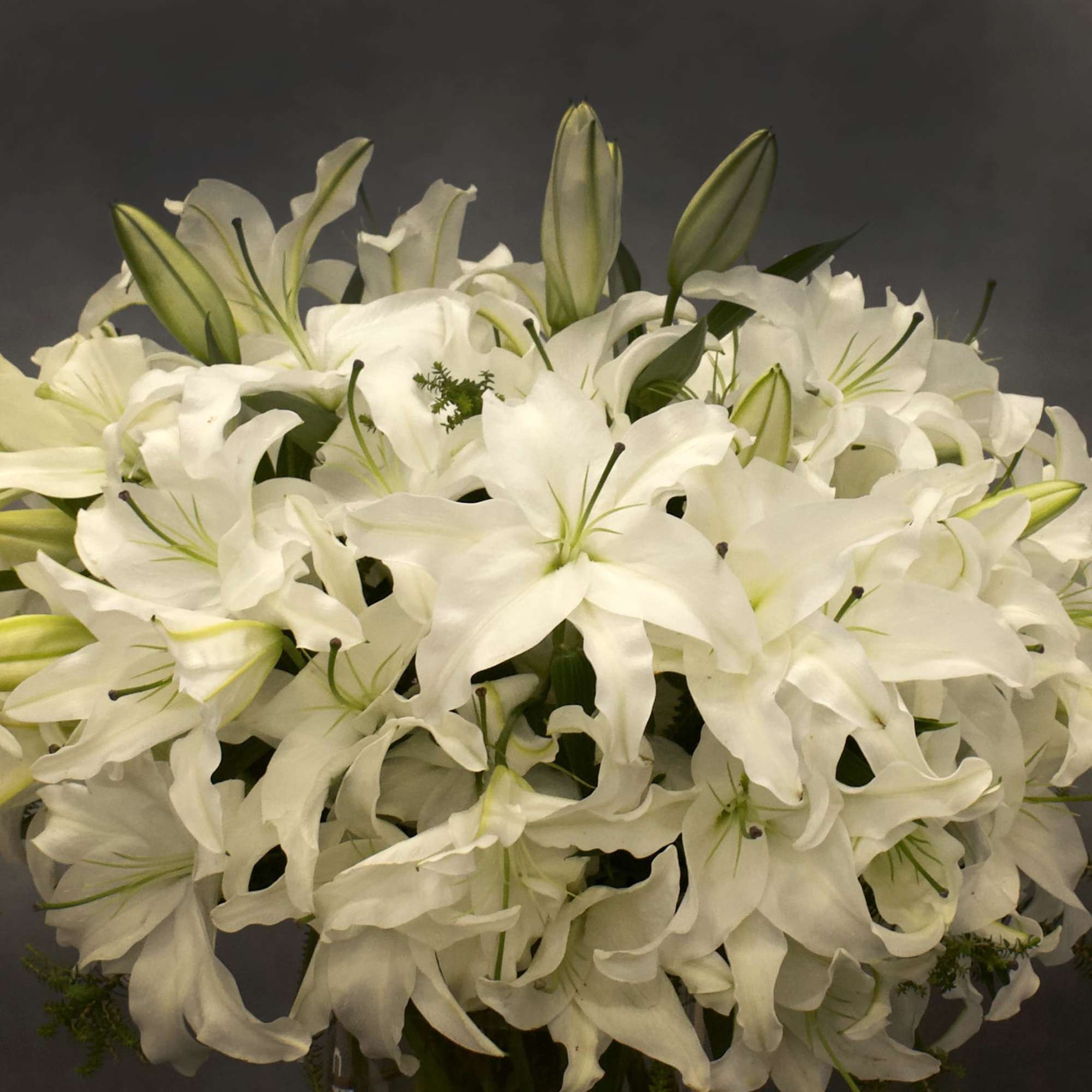 The design features white Casablanca lillies in a vase AS SHOWN PREMIUM