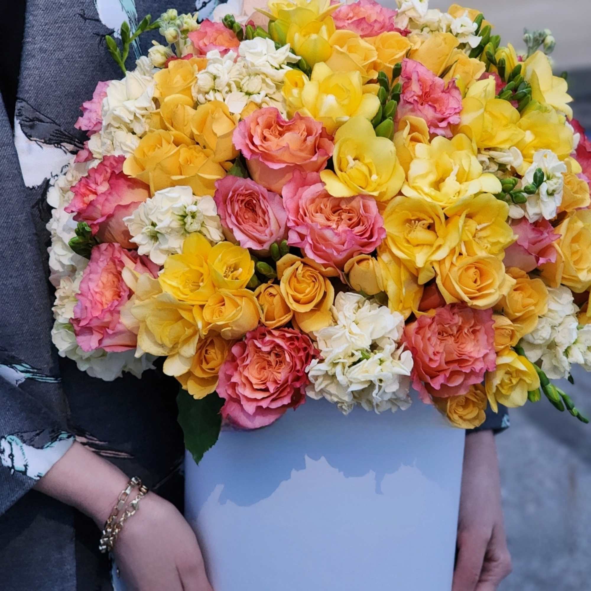 The hydrangeas complement the vibrant hues of the roses and spray roses