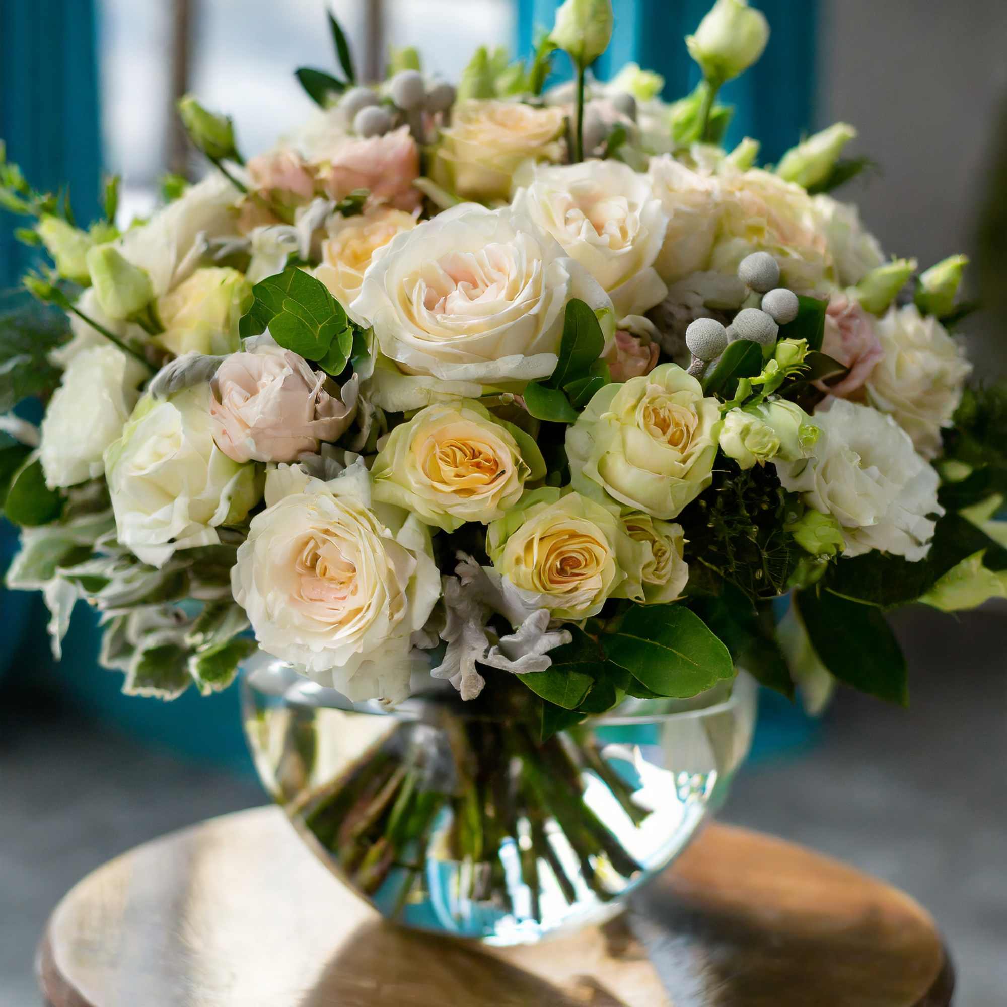A charming and beautiful bouquet featuring ivory roses, cream spray roses, and