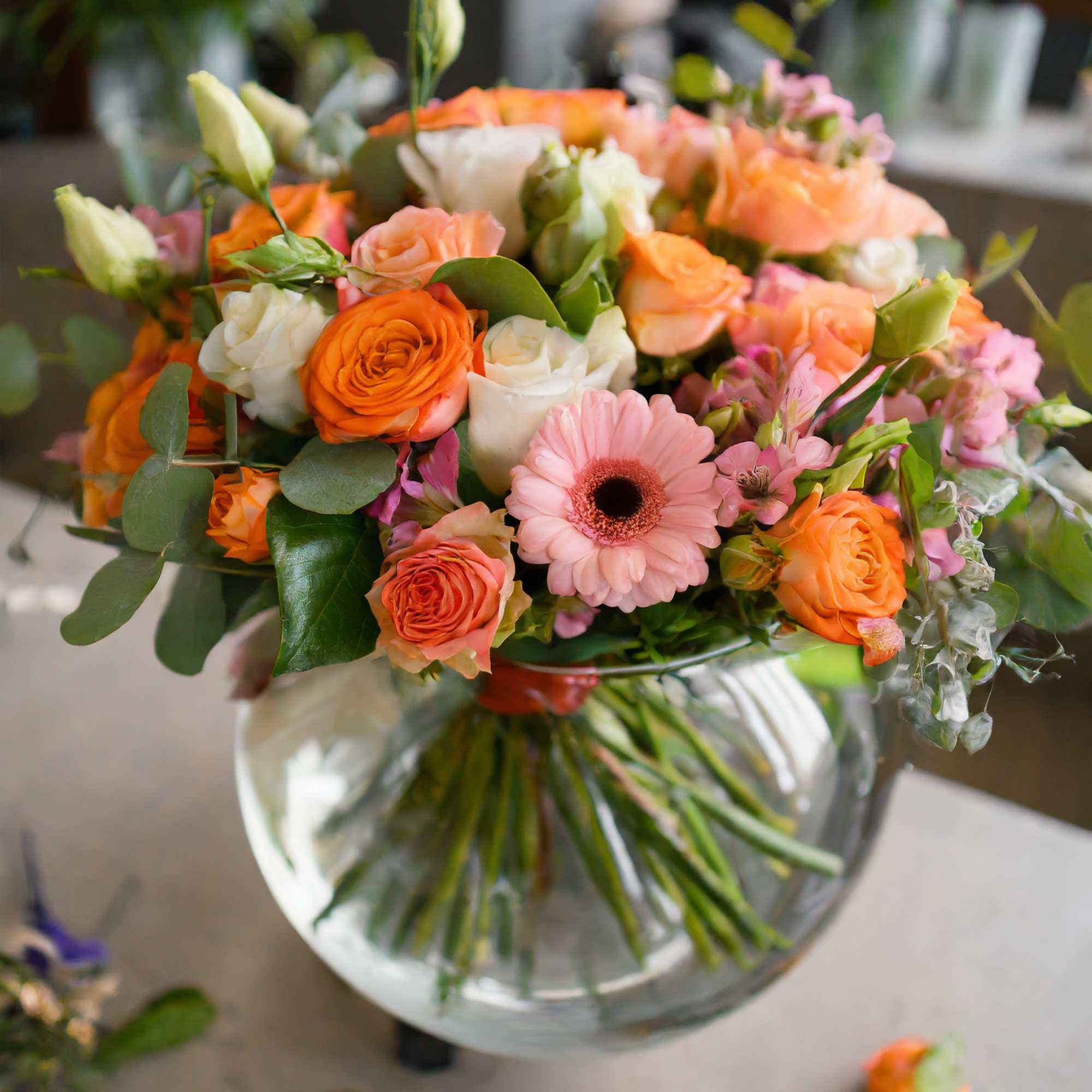 A composition of flowers in an orange and peach palette radiates warmth