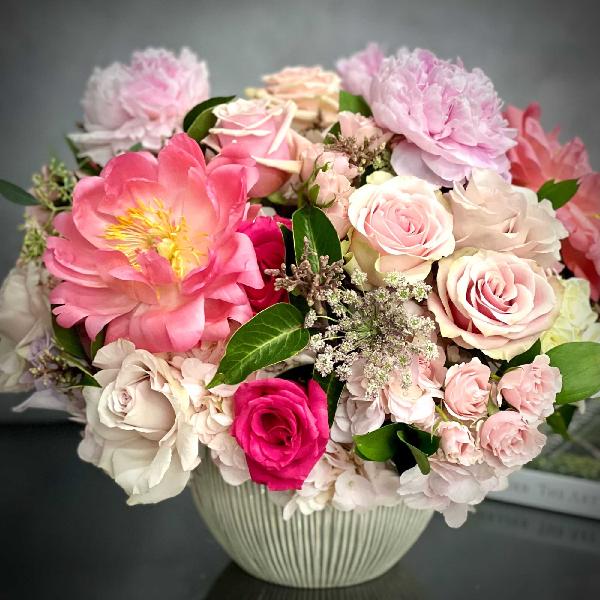 This round dish is abundantly filled with lovely Roses of varying hues