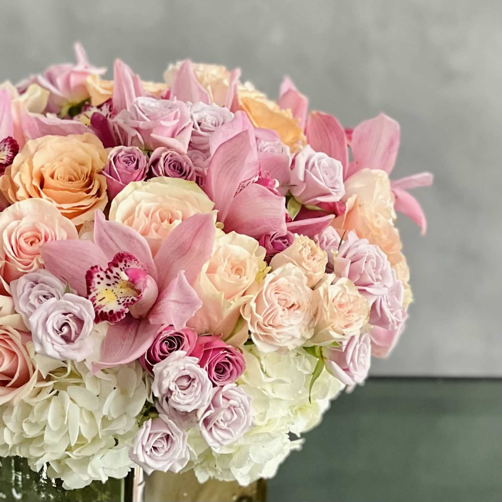 A beautiful array mixed flowers that include Roses, Orchids and Hydrangeas in
