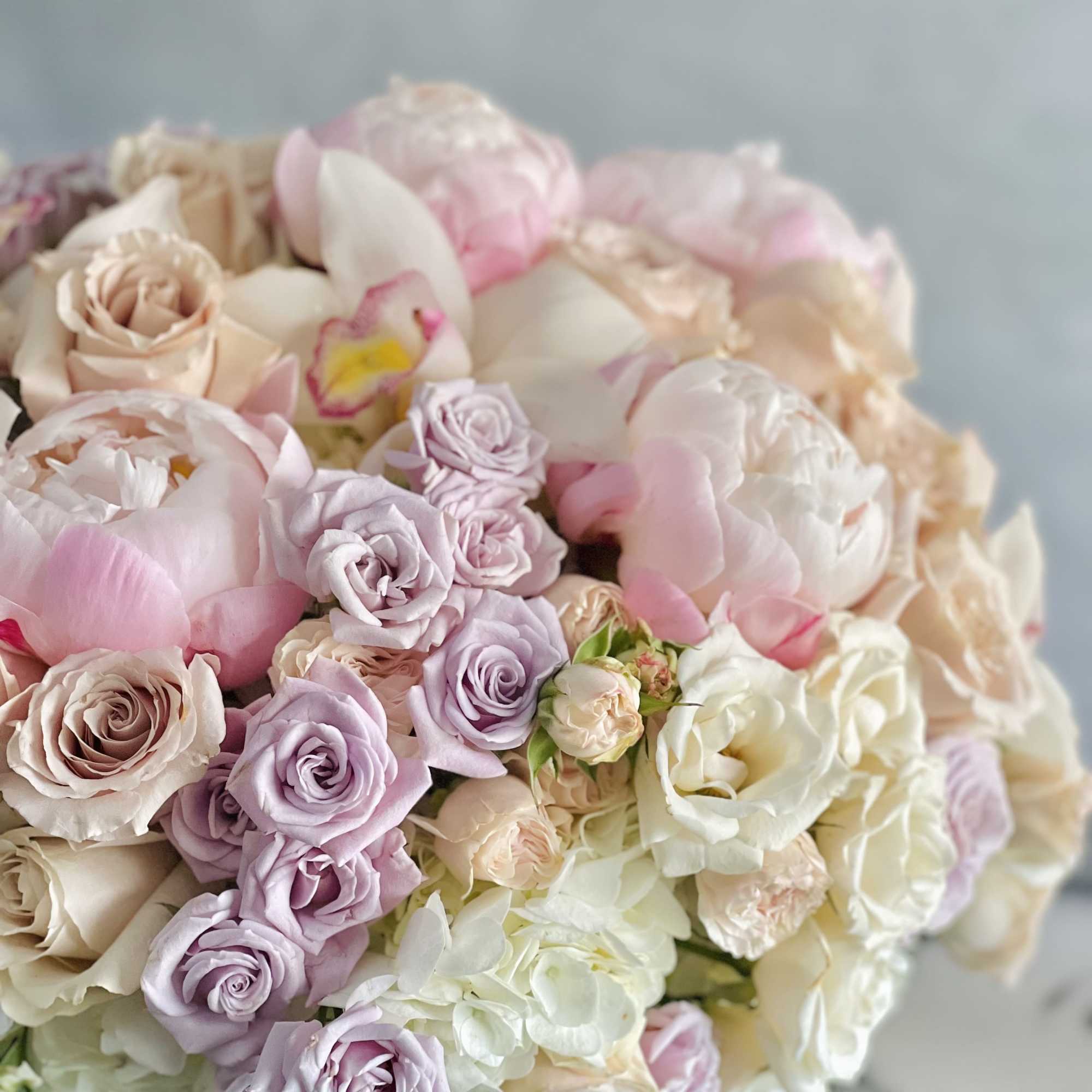 This beautiful array of light pink peonies, pink roses, lavender and light