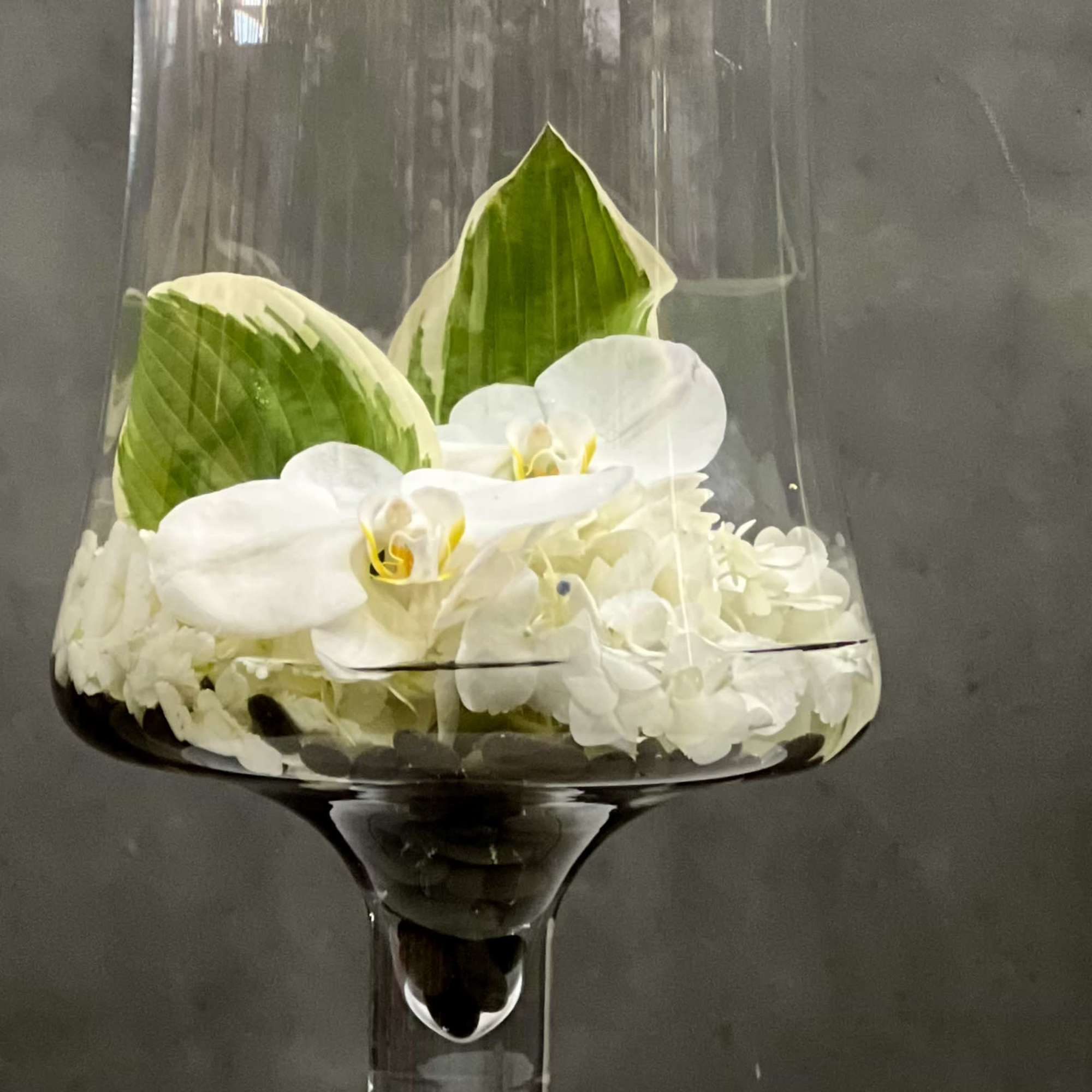 Overflowing of assorted Orchids artfully arranged in tall pedestal vase. This is