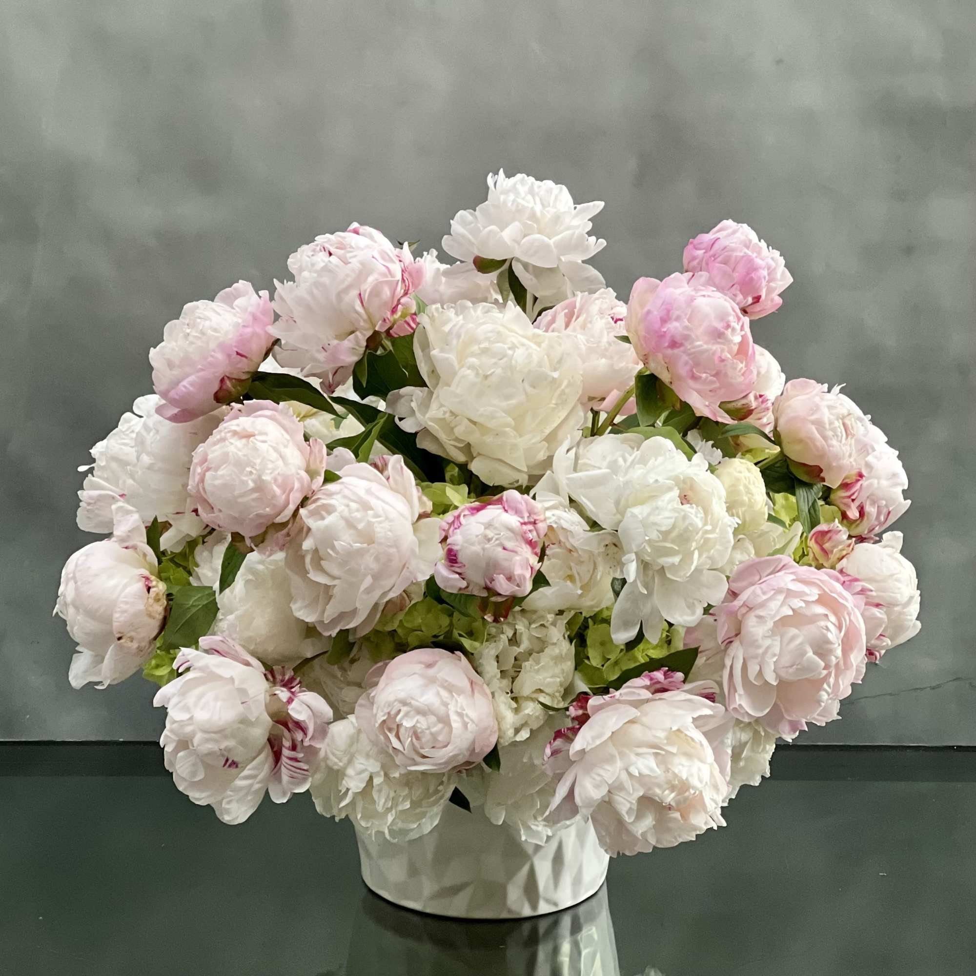 Graceful and stunning blooms of over 50 blush and pink peonies nested