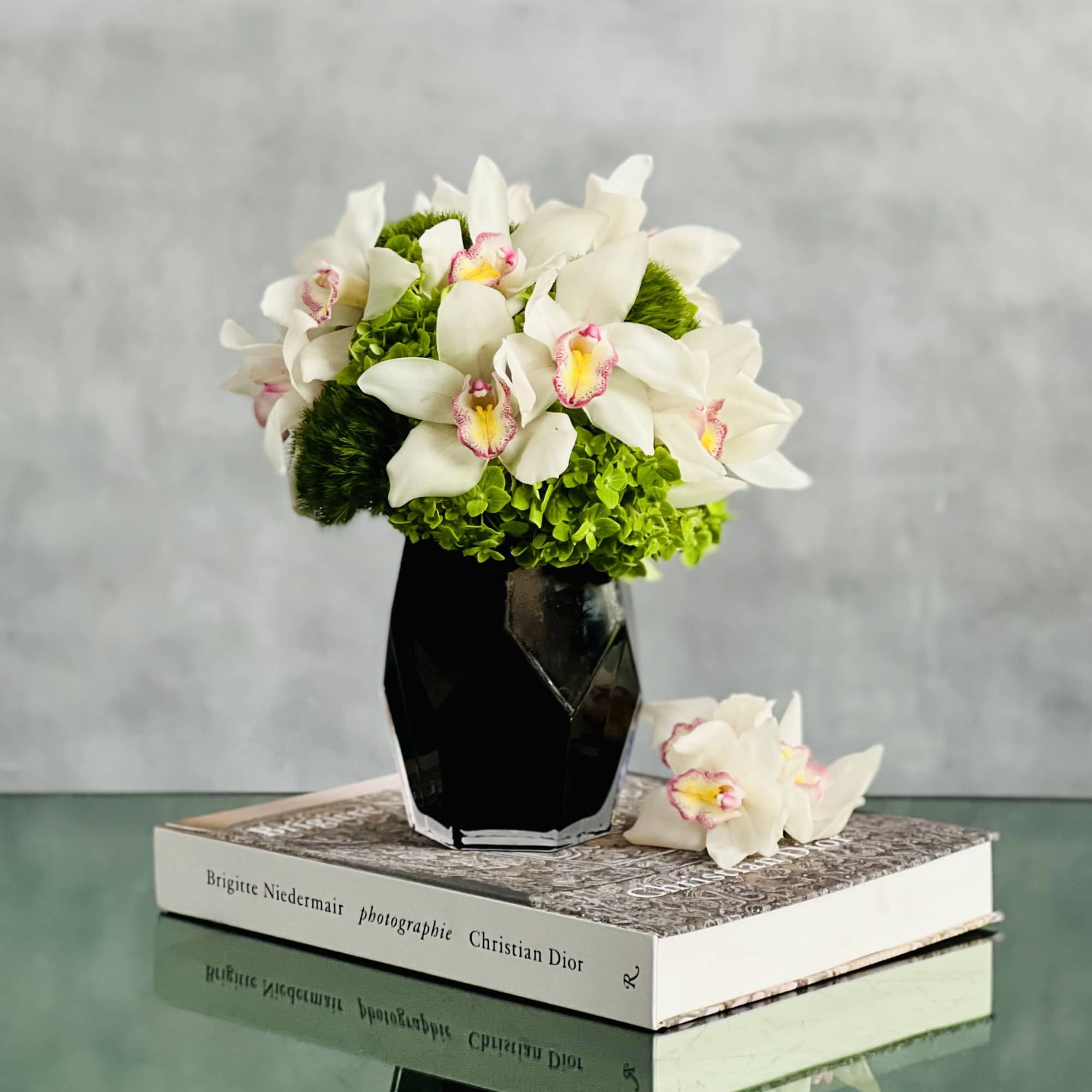 Distinctive snow white Cymbidium Orchids are amidst stark Green Moss Spheres in