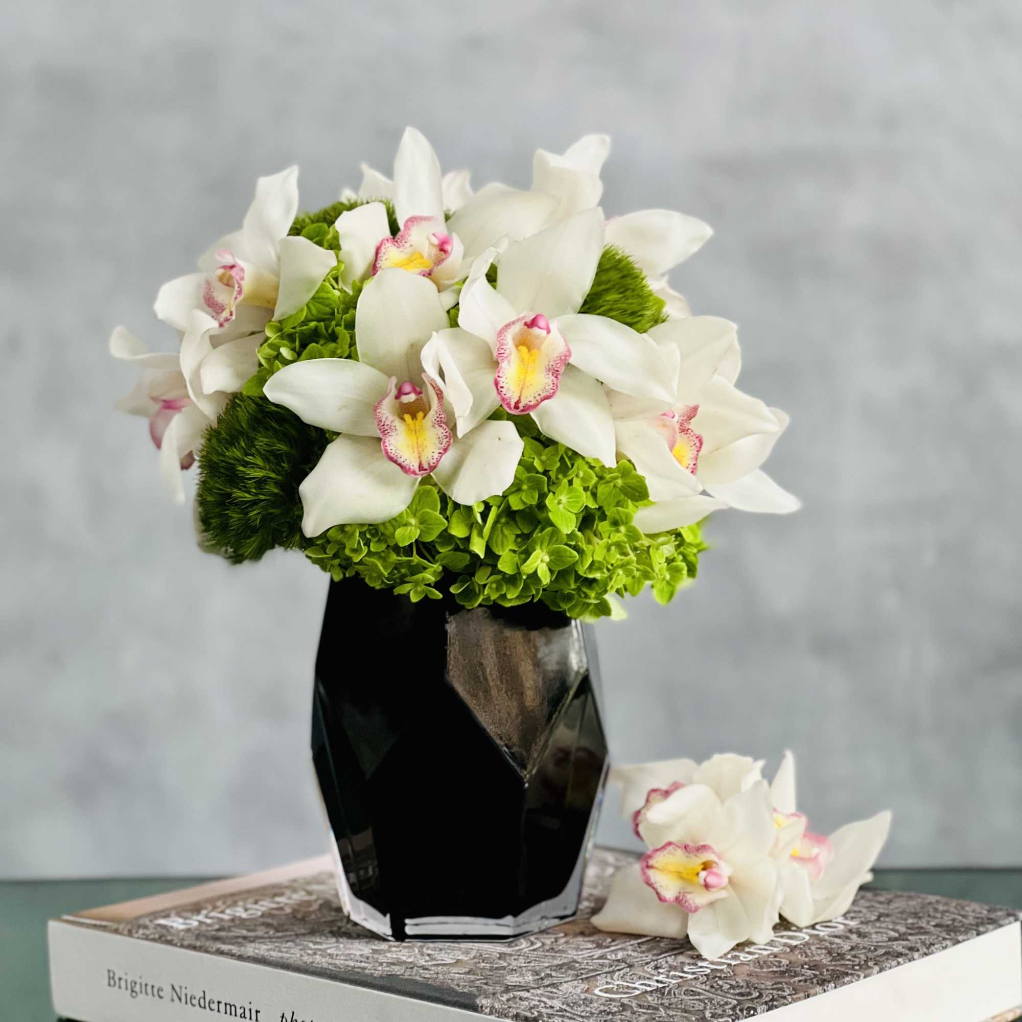 Distinctive snow white Cymbidium Orchids are amidst stark Green Moss Spheres in