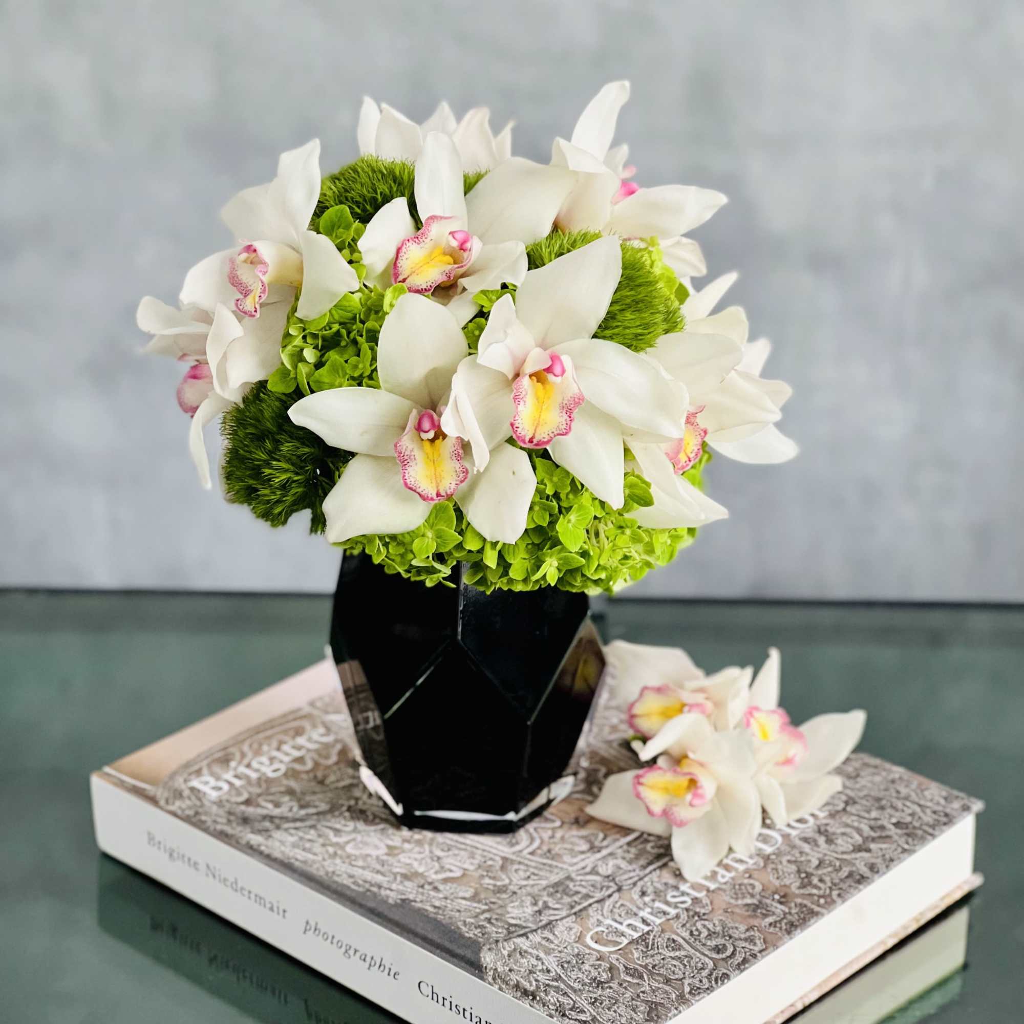 Distinctive snow white Cymbidium Orchids are amidst stark Green Moss Spheres in