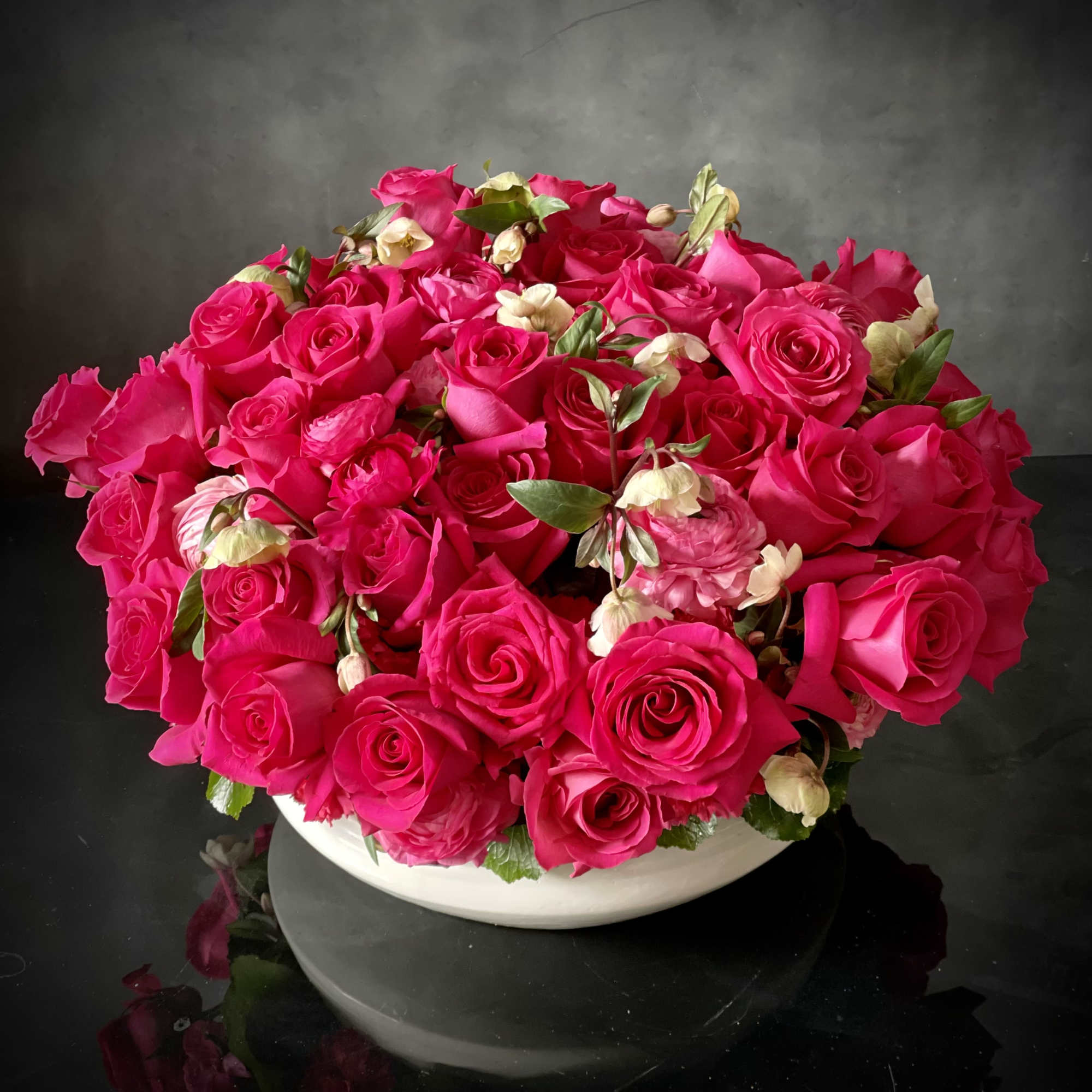 A variety of Roses and Ranunculus in deep blushing hues clustered in