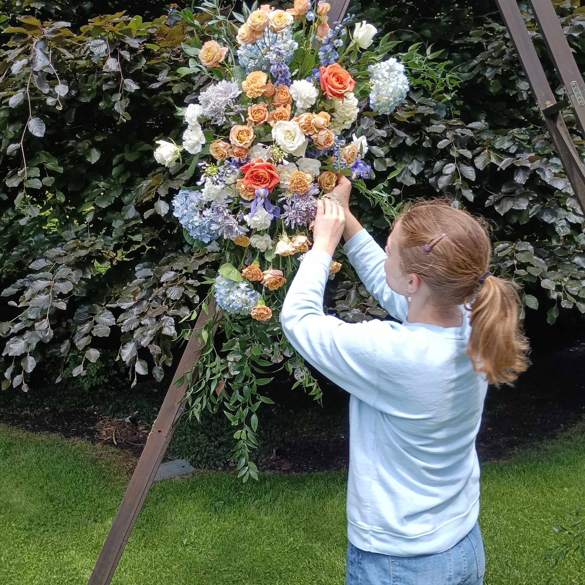 Beautiful mix of orange, blue and white flowers with the fillers and