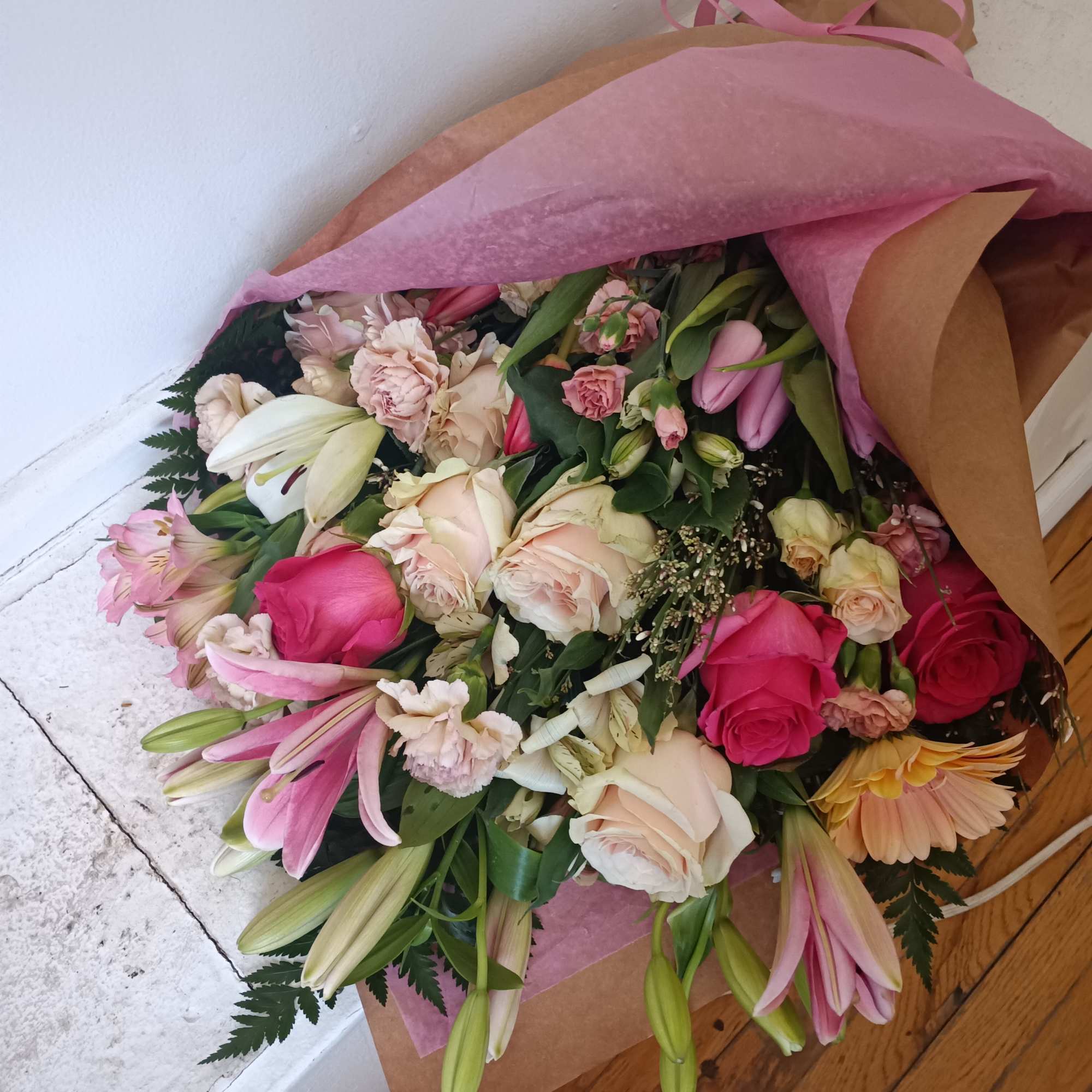 Hend tied wrap of light pink and hot pink lilies, roses, carnations