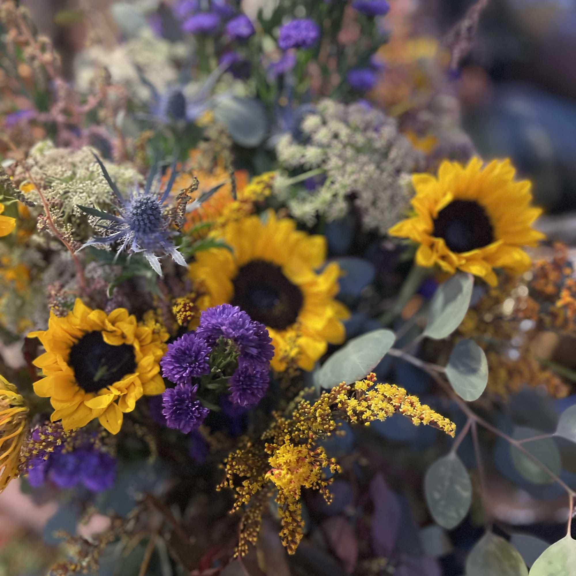 Yellow sunflowers, purple Saint Ann wildflowers, and eucalyptus create a stunning combination