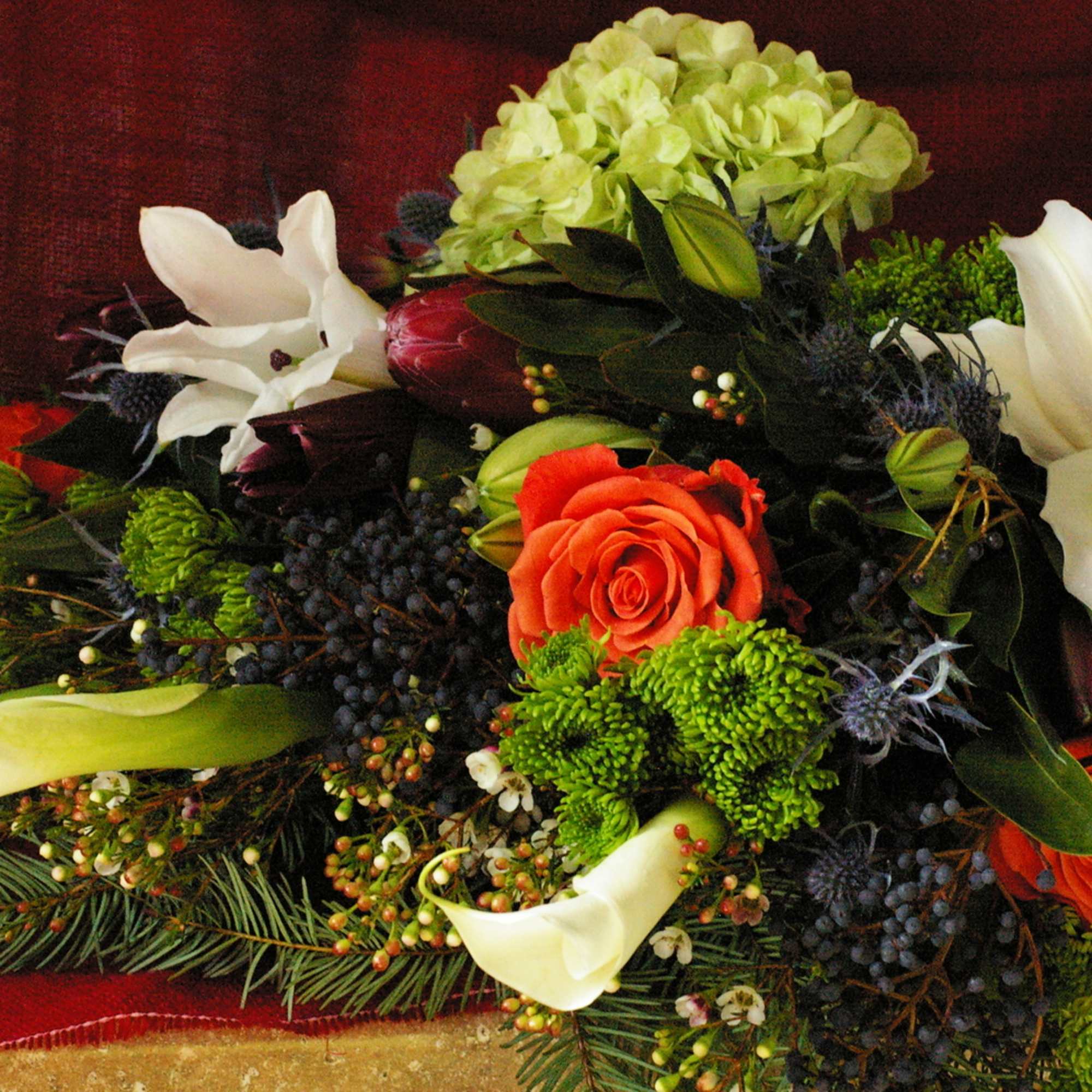 Winter arm bouquet with casablanca lilies, protea, blue thistle, coral roses, wax