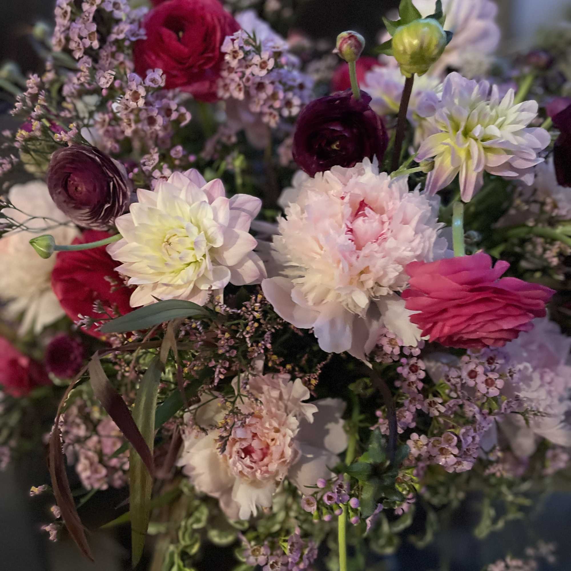 Marvelous seasonal floral arrangement with dahlias, ranunculus , peonies , and chrysanthemums.