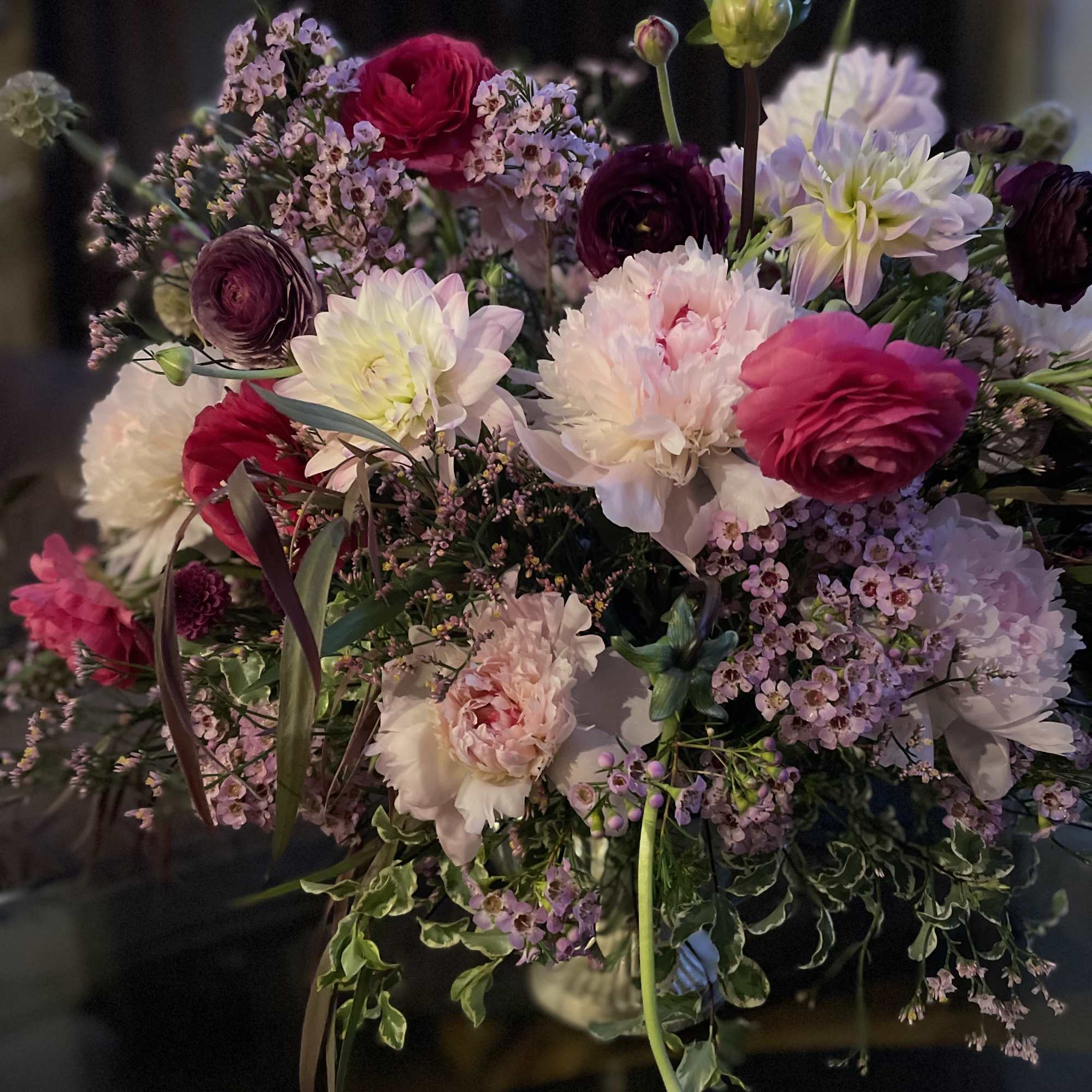 Marvelous seasonal floral arrangement with dahlias, ranunculus , peonies , and chrysanthemums.