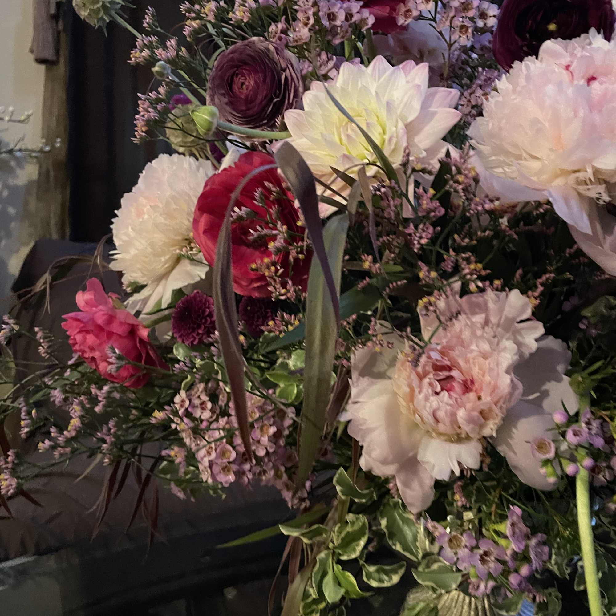 Marvelous seasonal floral arrangement with dahlias, ranunculus , peonies , and chrysanthemums.