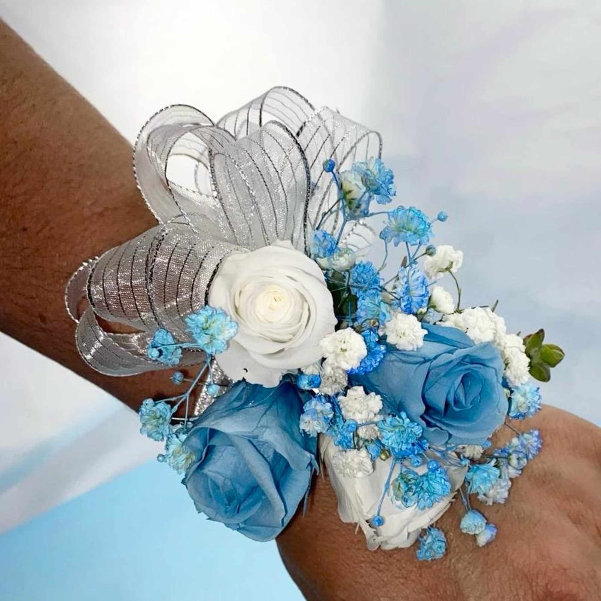 A classic light blue preserved rose and baby&#039;s breath corsage compliments any