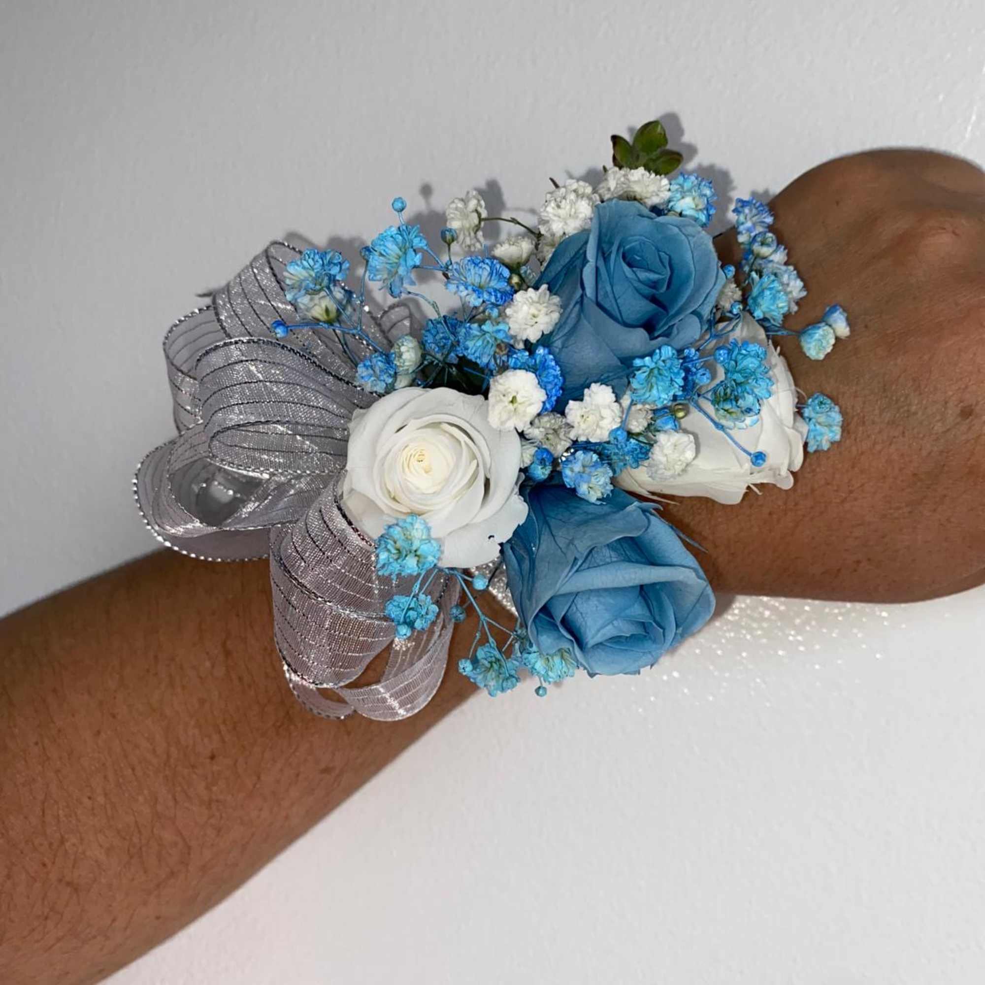 A classic light blue preserved rose and baby&#039;s breath corsage compliments any