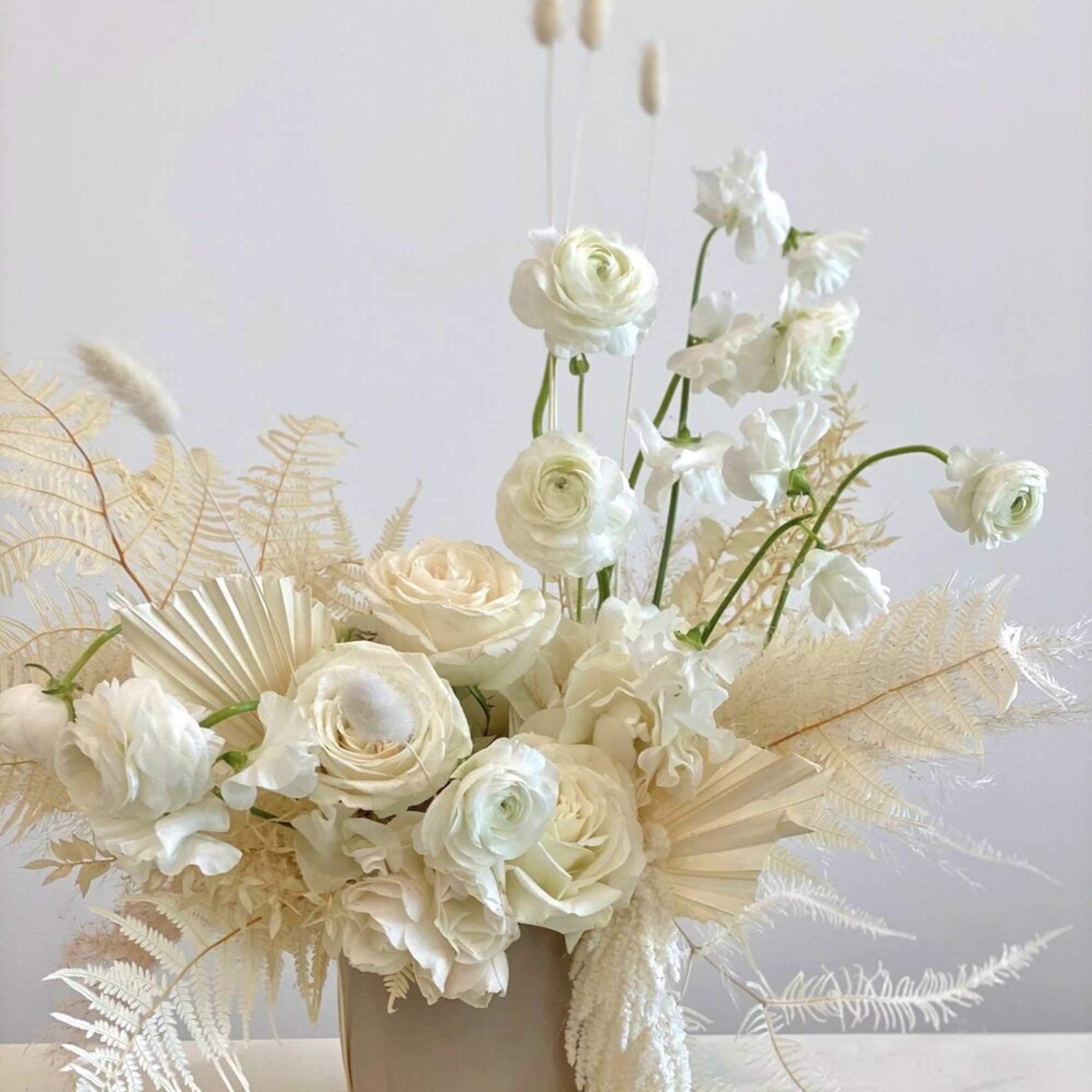 - Charming arrangement in soft whites and neutral tones
- Adorned with delicate