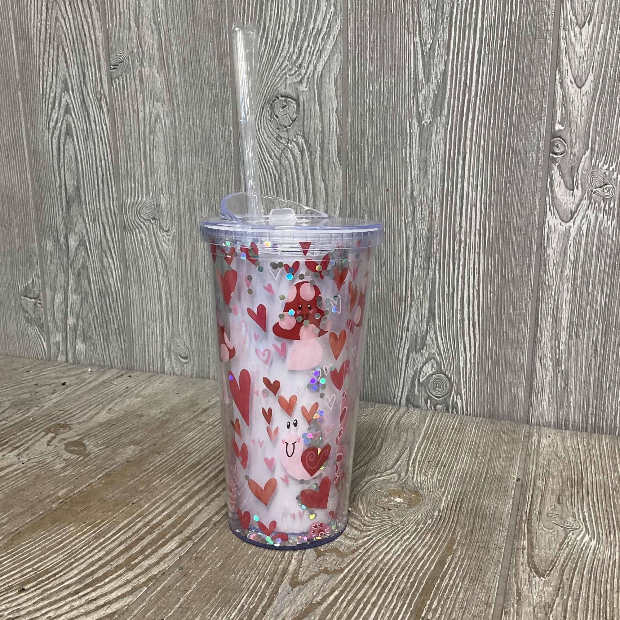 Acrylic travel cup with fun smiling snails, mushrooms, and butterflies. There are Acrylic travel cup with fun smiling snails, mushrooms, and butterflies. There are