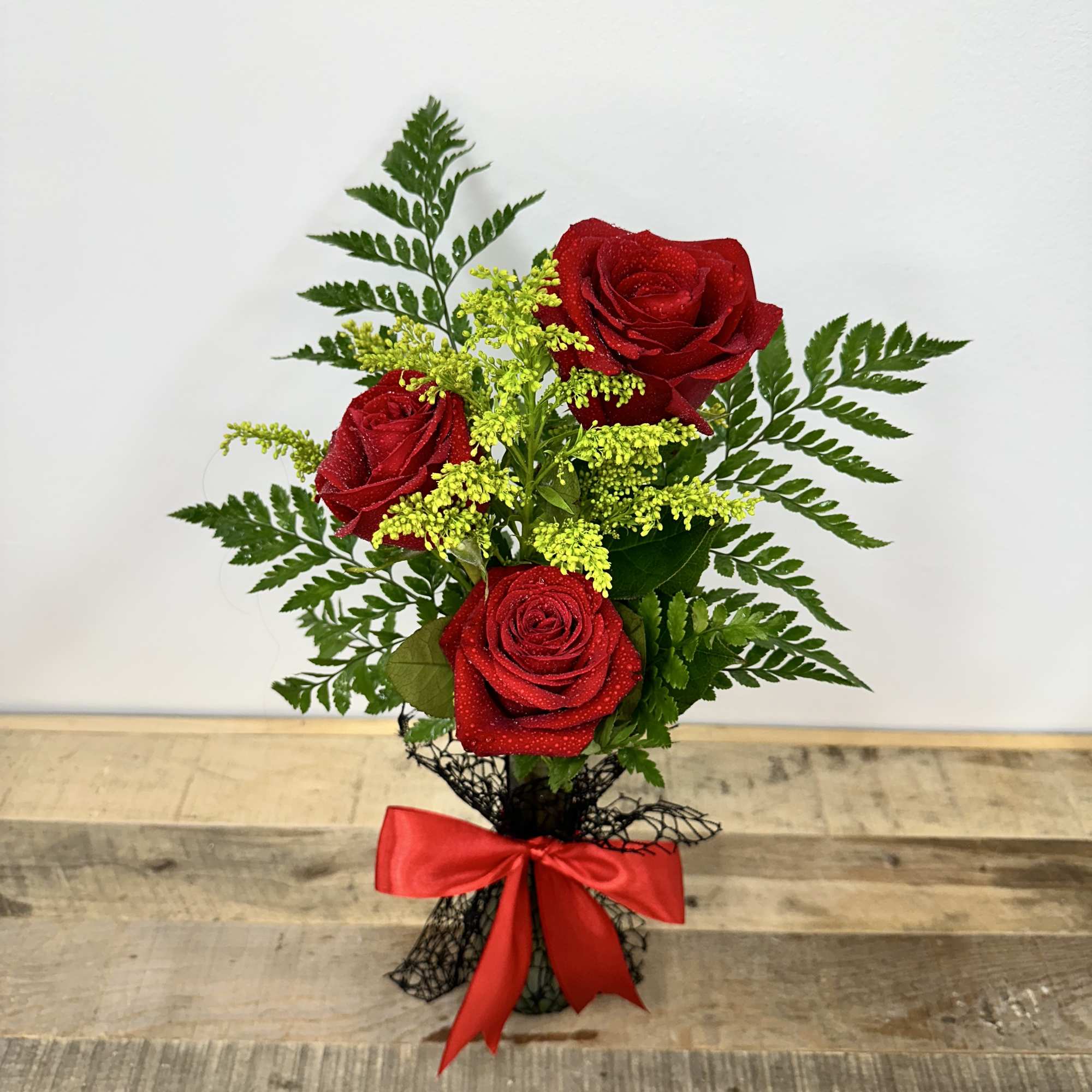 "Timeless Trio" features a small vase with lush greenery, elegantly showcasing three