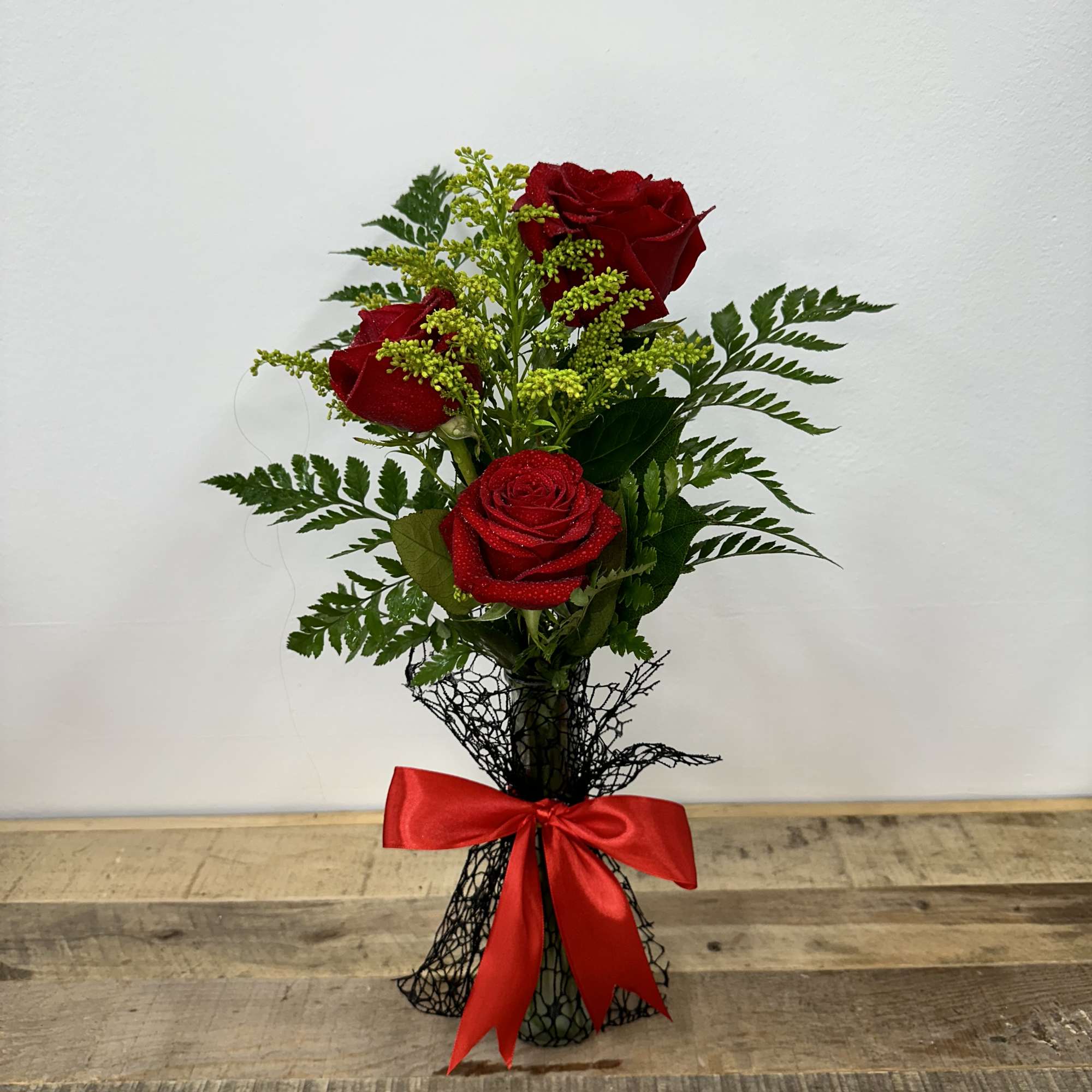 "Timeless Trio" features a small vase with lush greenery, elegantly showcasing three