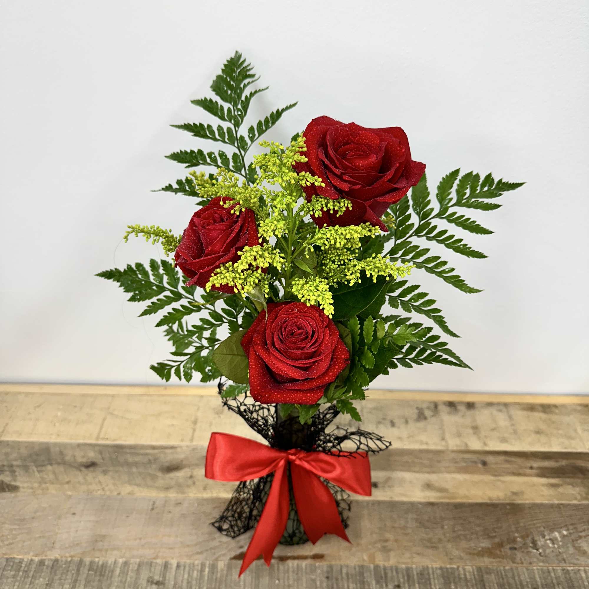 "Timeless Trio" features a small vase with lush greenery, elegantly showcasing three