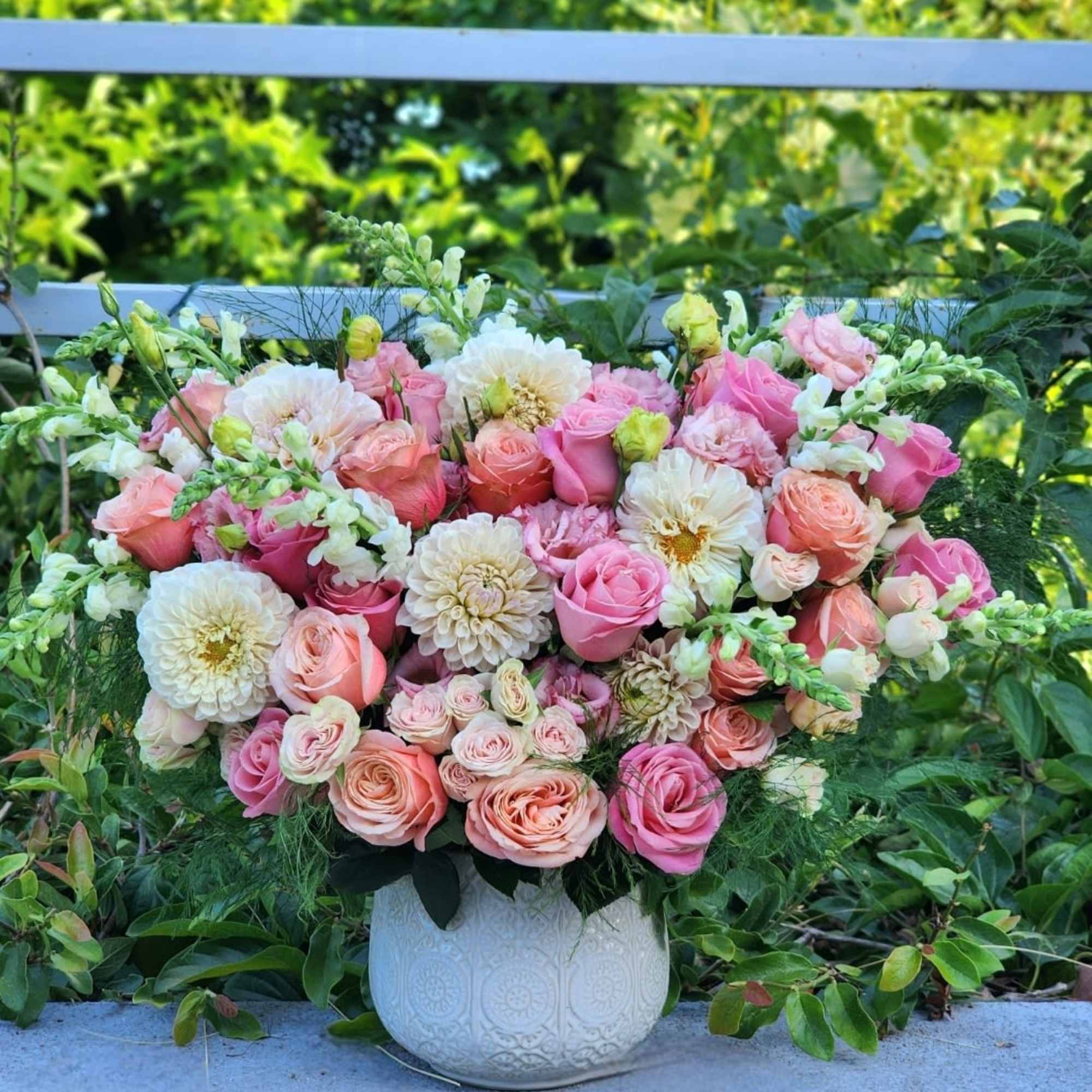 This stunning floral arrangement in a ceramic vase features  of peach