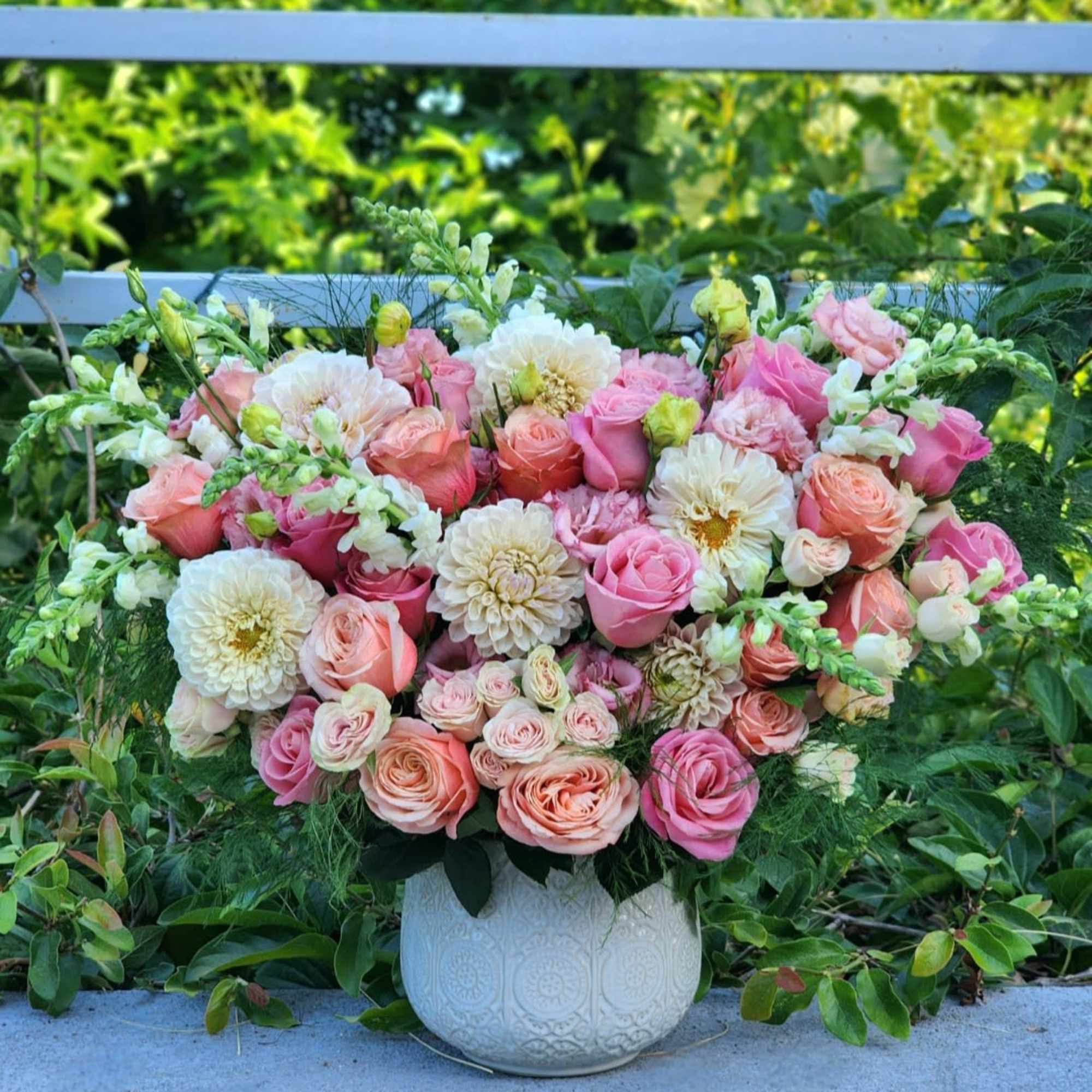 This stunning floral arrangement in a ceramic vase features  of peach