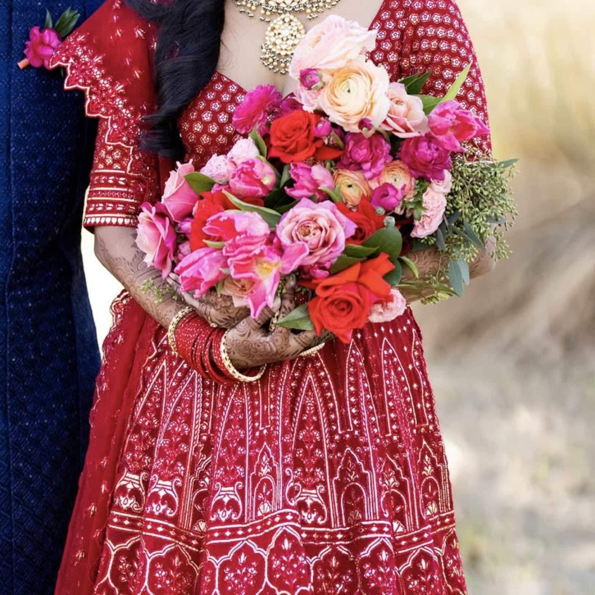 - Richly layered bouquet featuring vibrant reds, soft pinks, and delicate pale