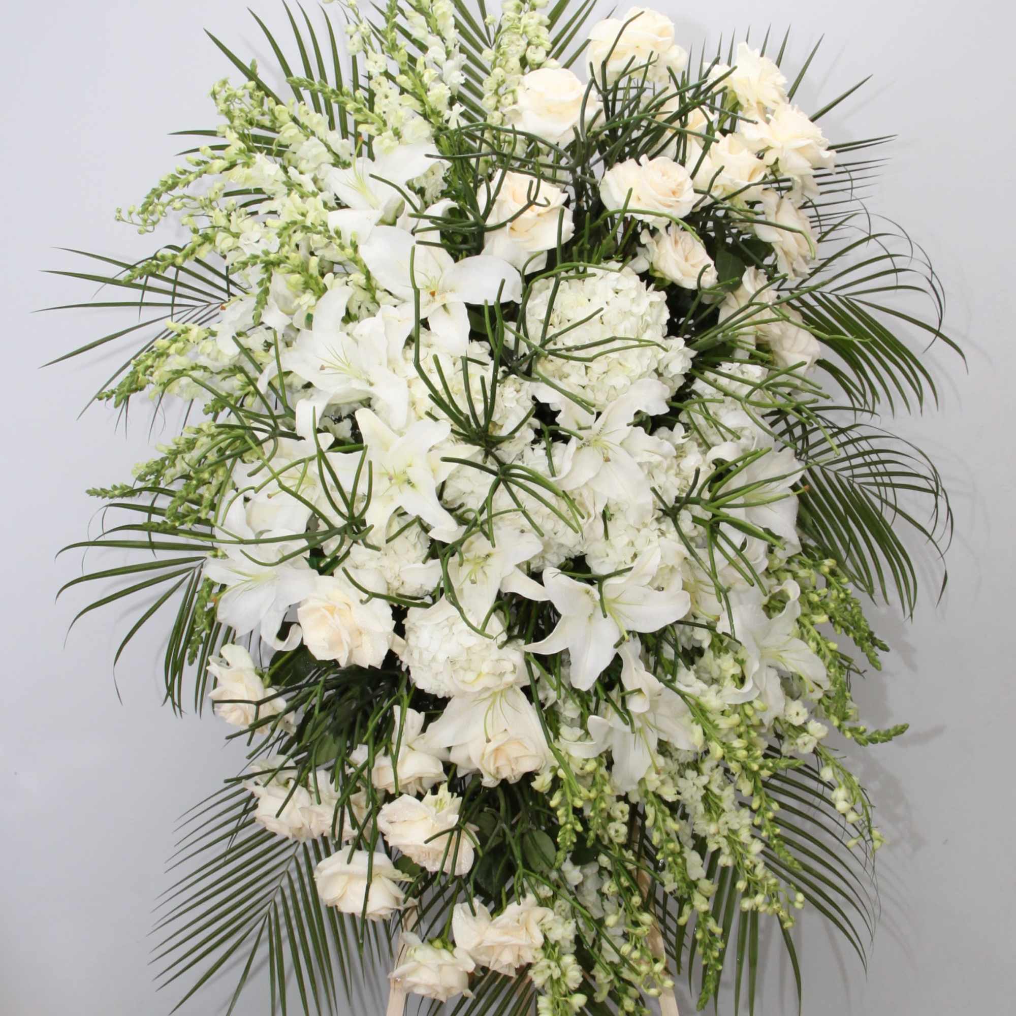 This spray is all white with a touch of seasonal greens.

We include