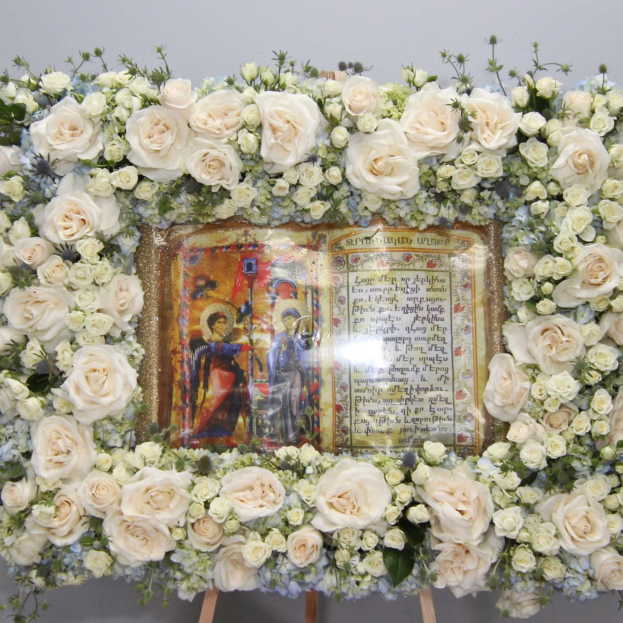 With a subtle theme of blue, this frame arrangement includes roses, hydrangeas