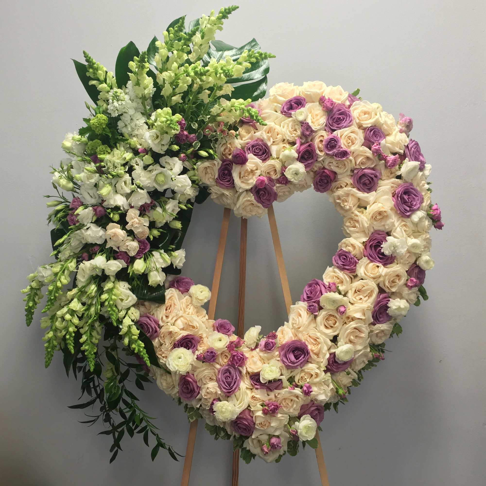 The heart is made up of white and lavender roses, snapdragons, and