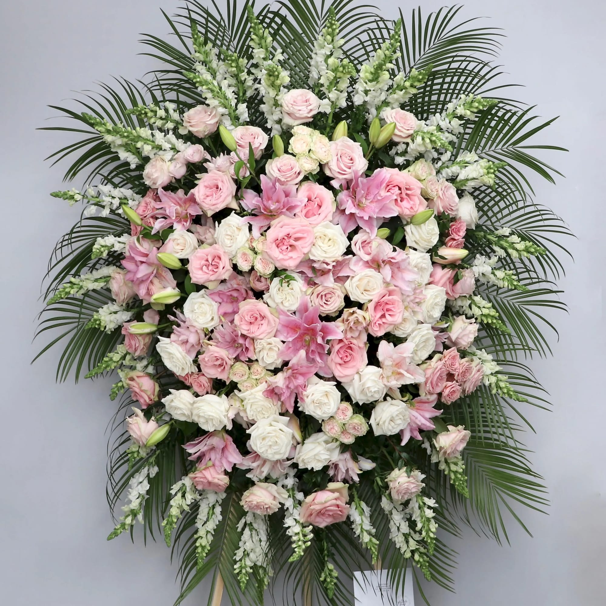 With various shades of pink, this arrangement includes roses, stargazer lilies, and