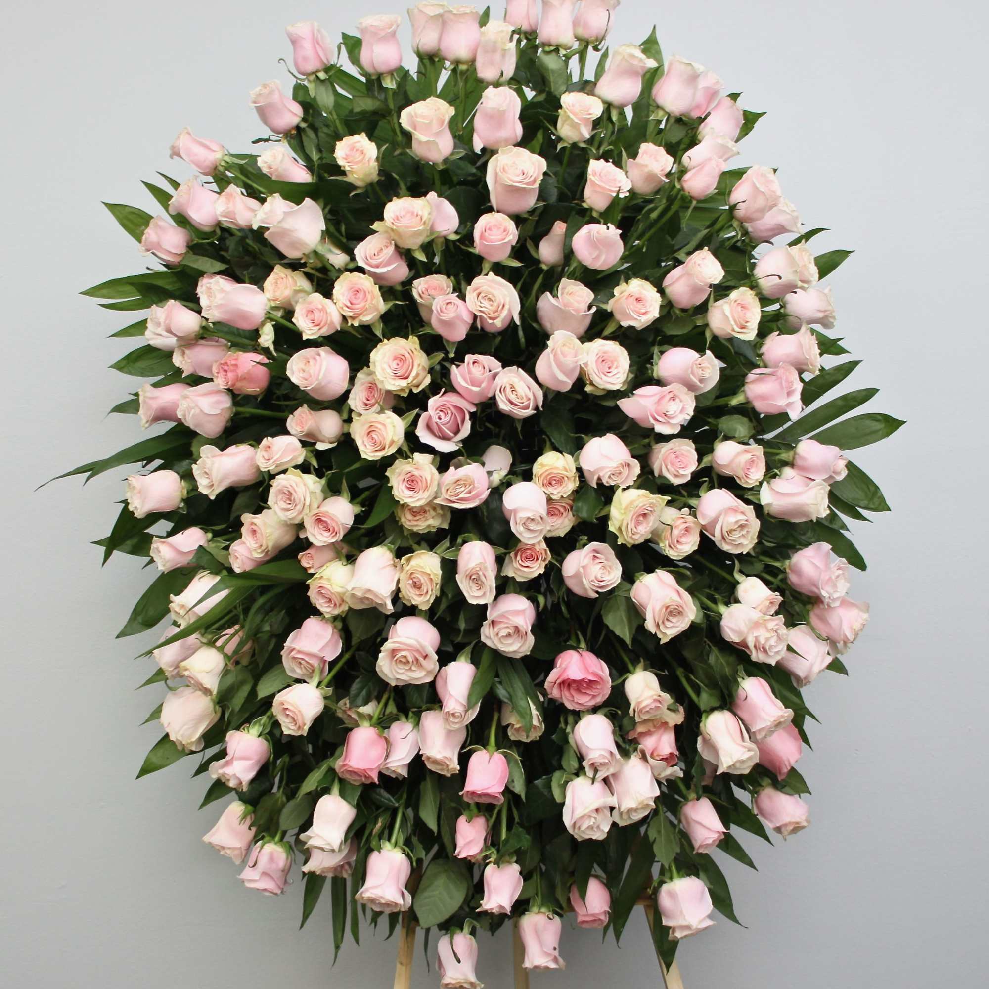 This sympathy spray includes bright pink roses, and elegant seasonal greens.

We include