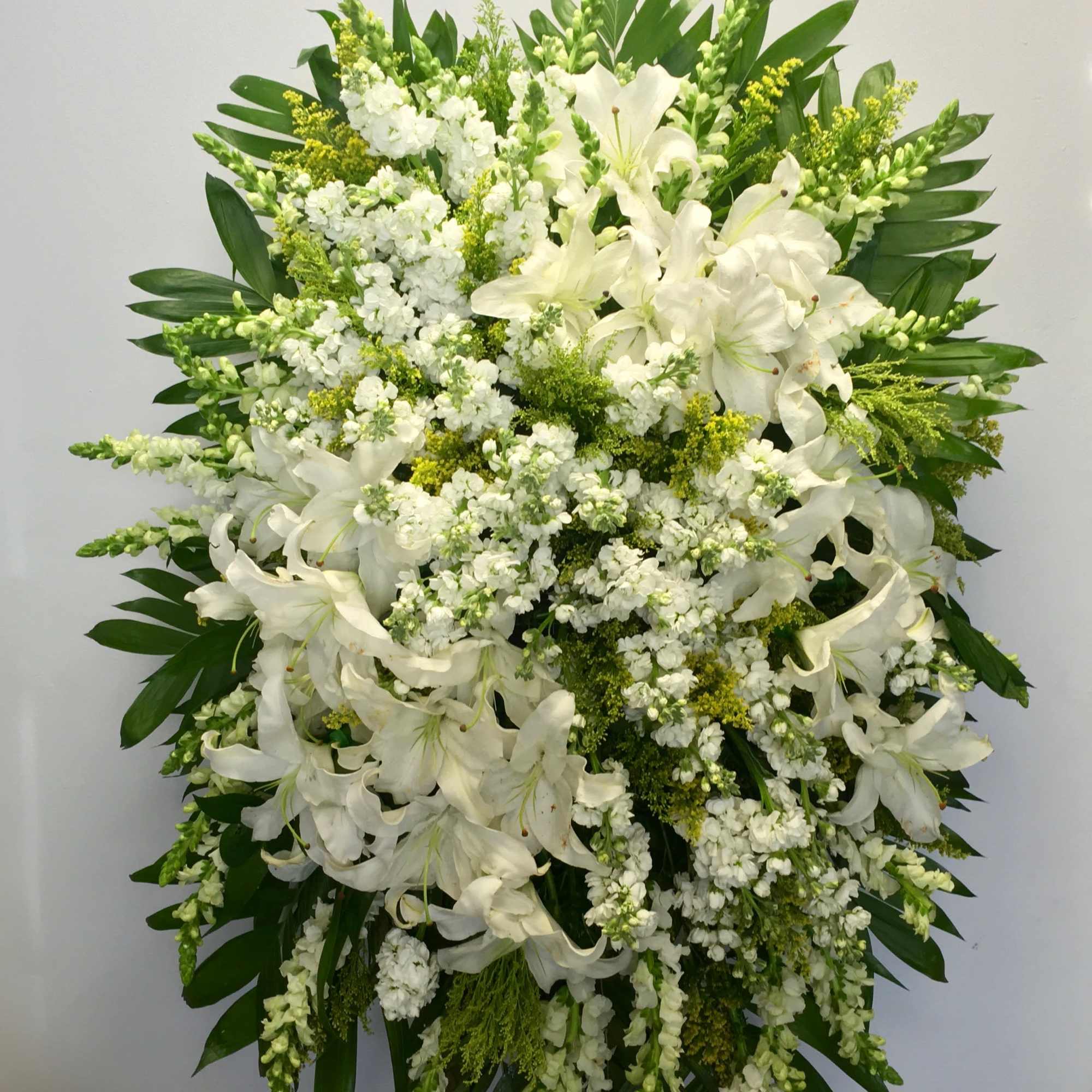 This white spray includes stargazer lilies and fluffy florals to create a