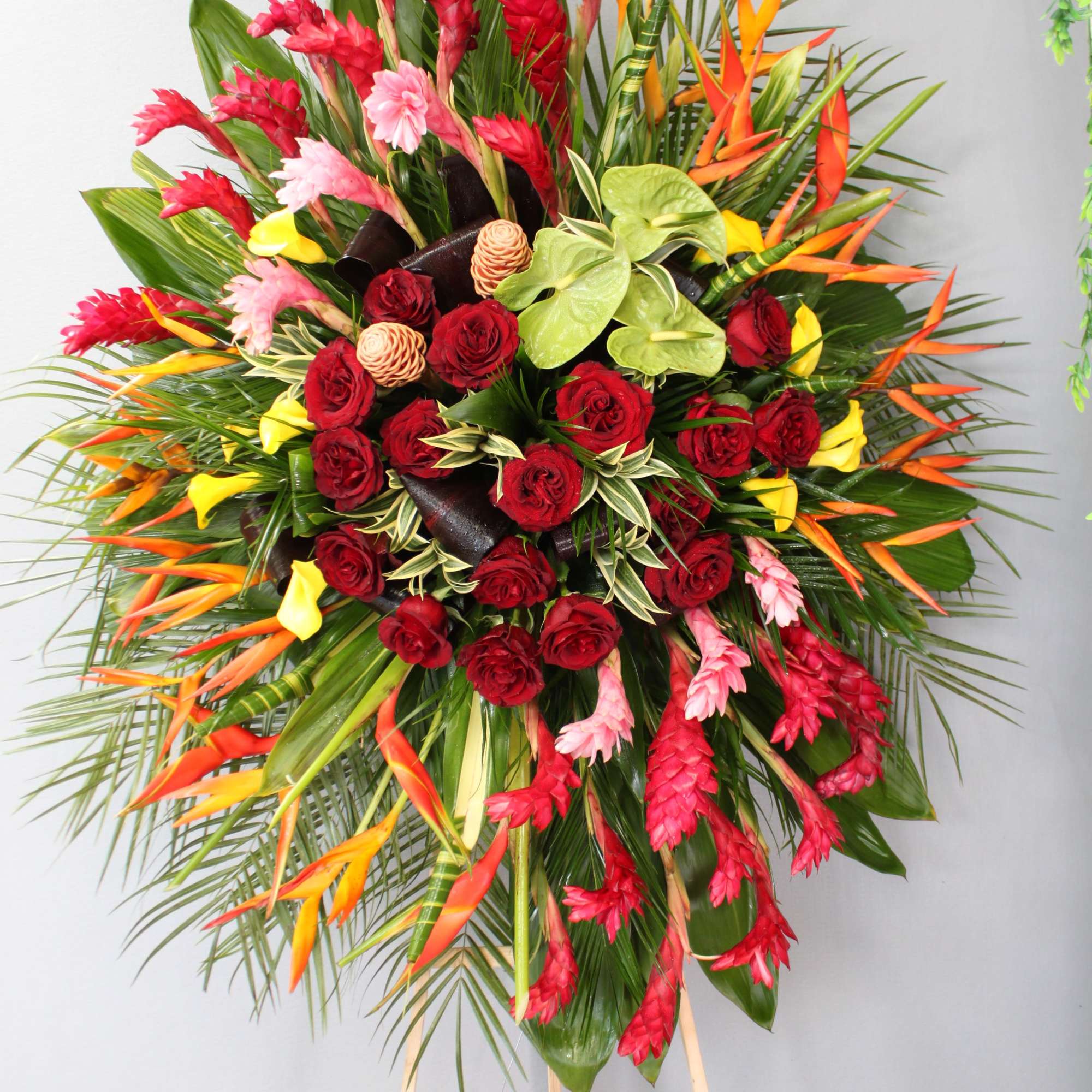 This spray contains tropical themed florals, roses, and seasonal greens. 

We include