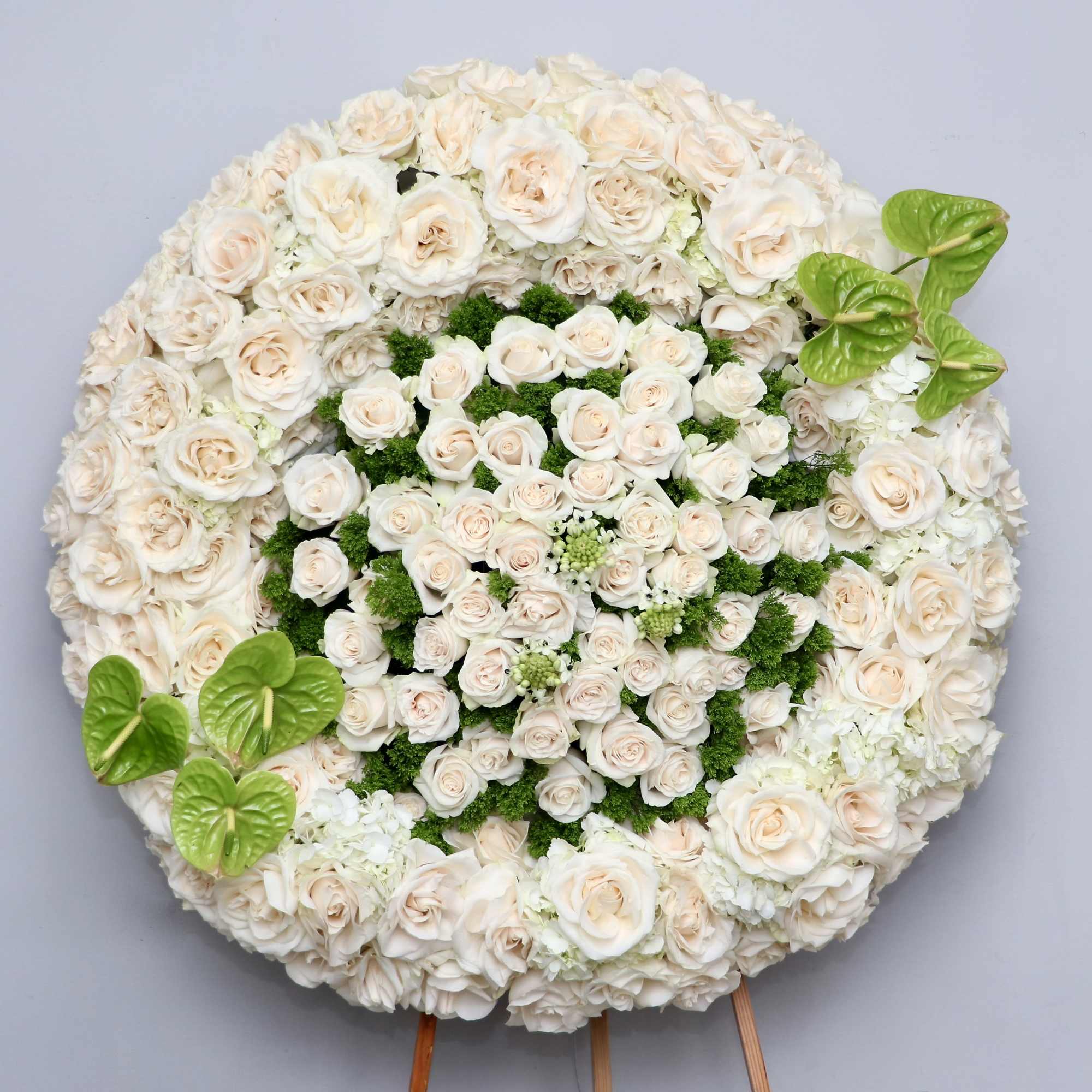 This full wreath is covered in beautiful white roses and orchids and