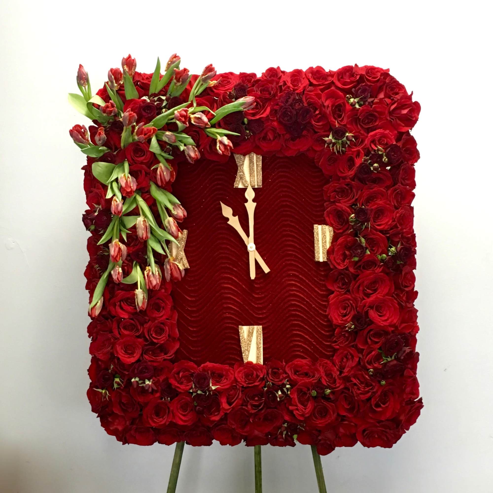 Covered in red roses, this sympathy wreath also contains an accent of