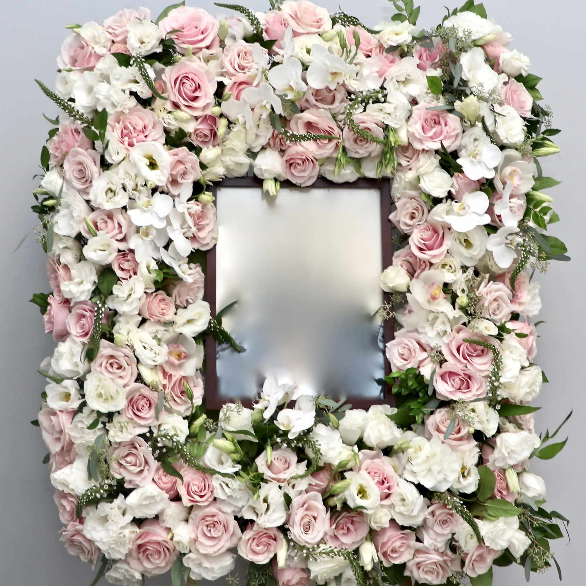 With a mix of white and pink roses, orchids and seasonal greens