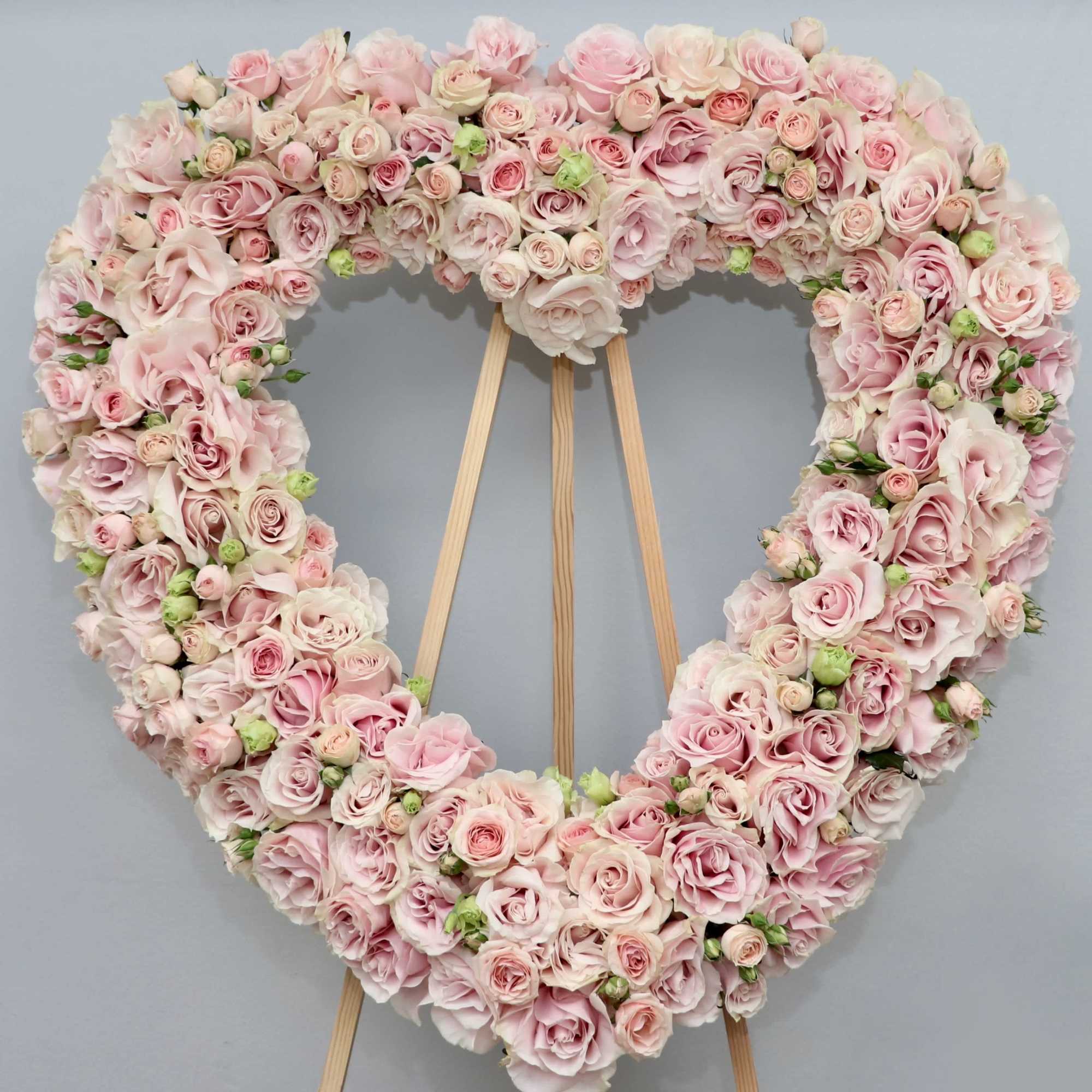 A heart made with blush pink roses and other seasonal florals.

We include