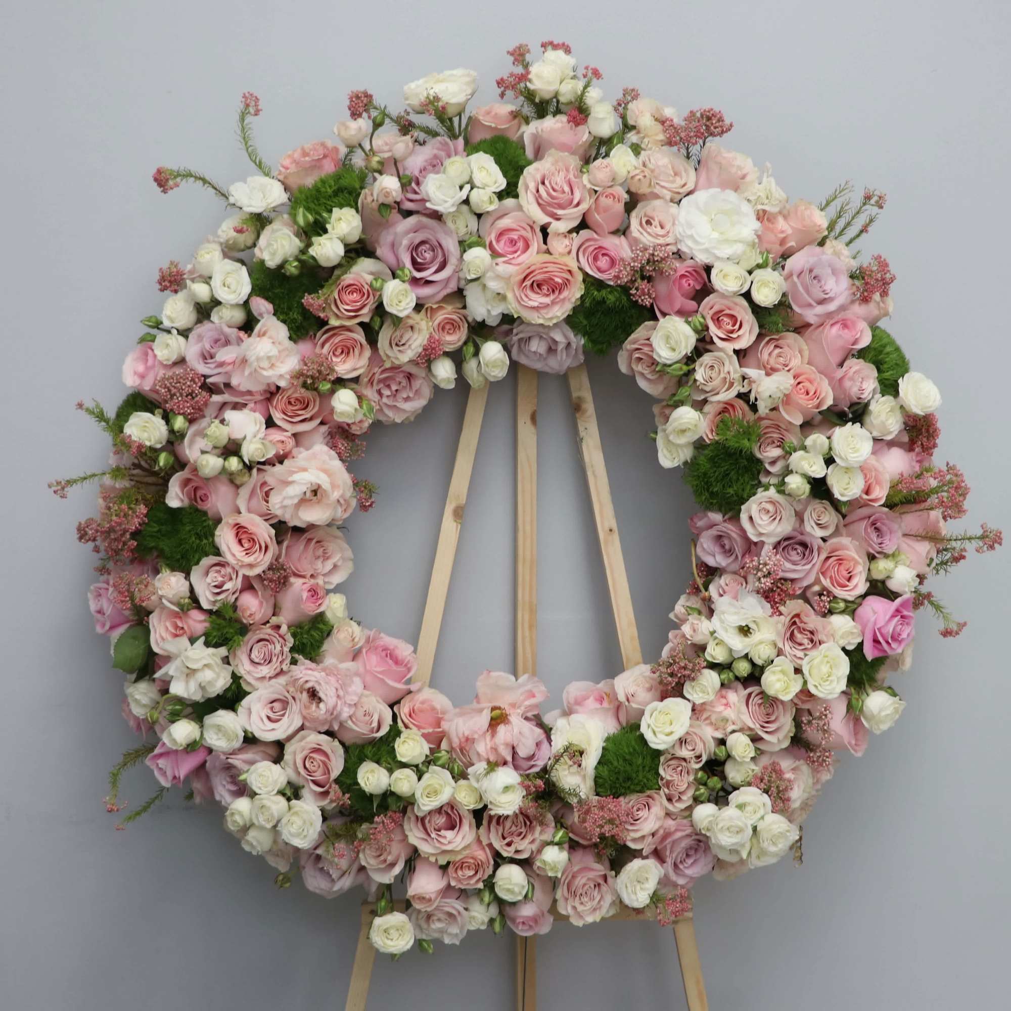 With a mix of pink, white, and green florals, this sympathy wreath