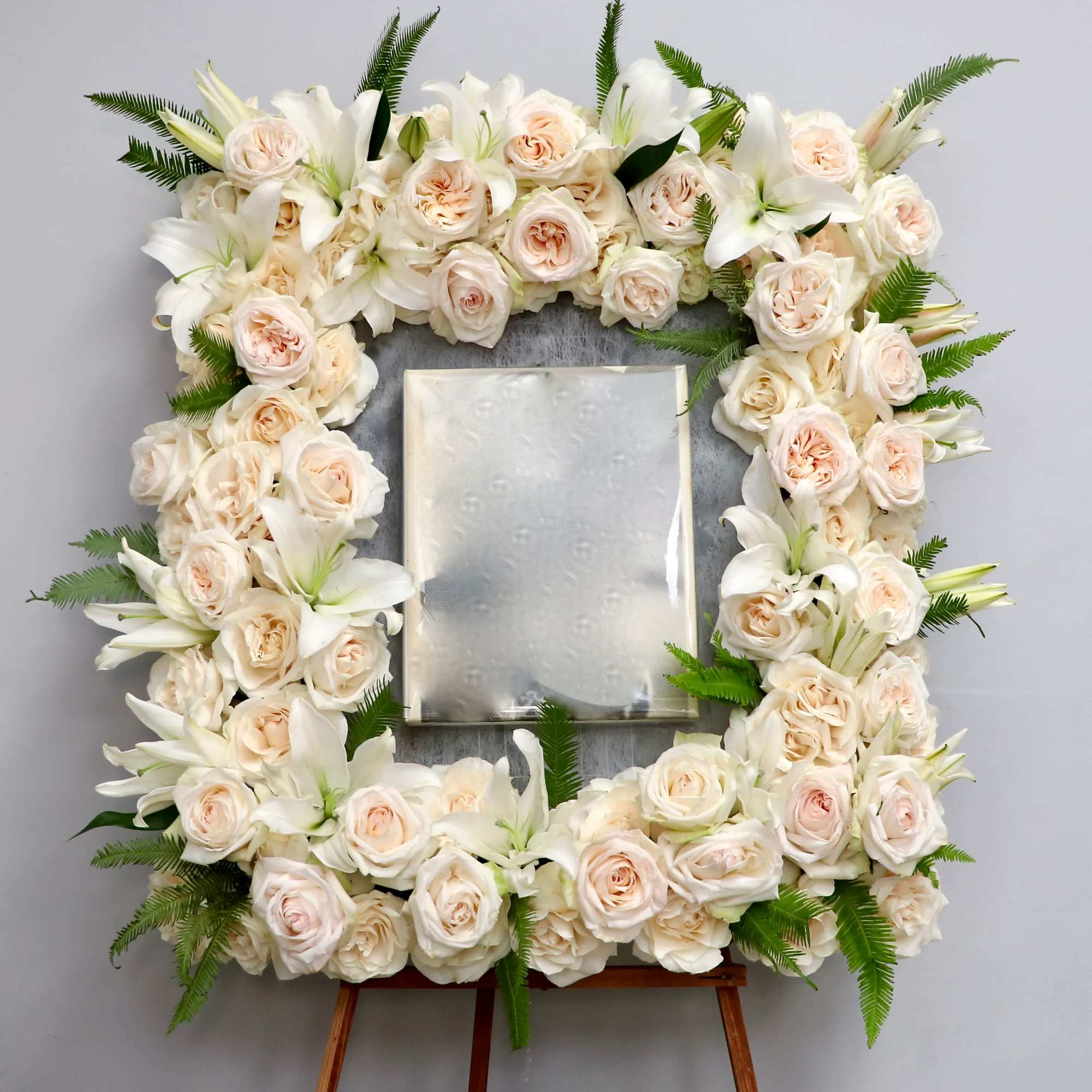 With a mix of peach and white roses, lilies and season greenery