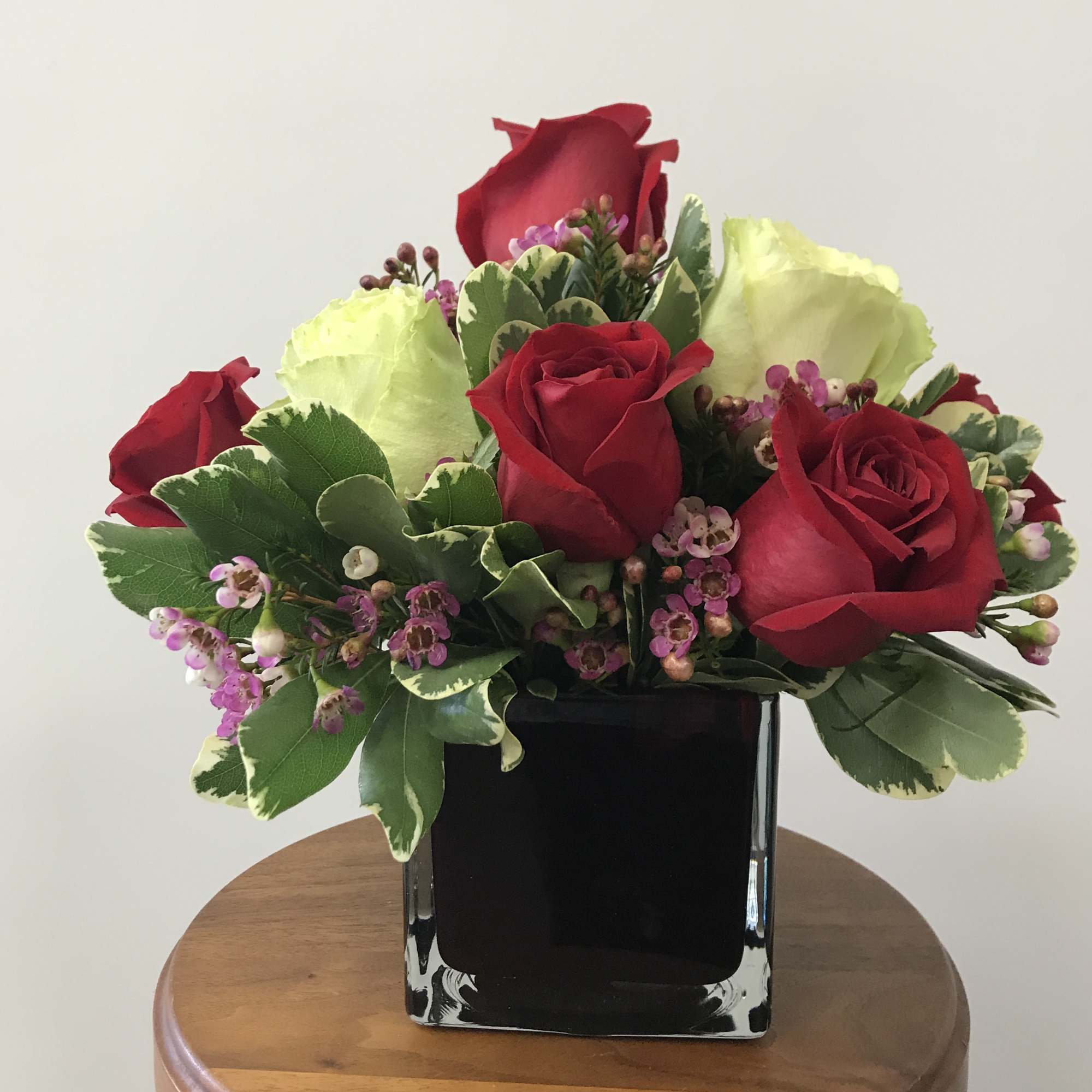 A graceful bouquet of 10 red and white roses with waxflower (or