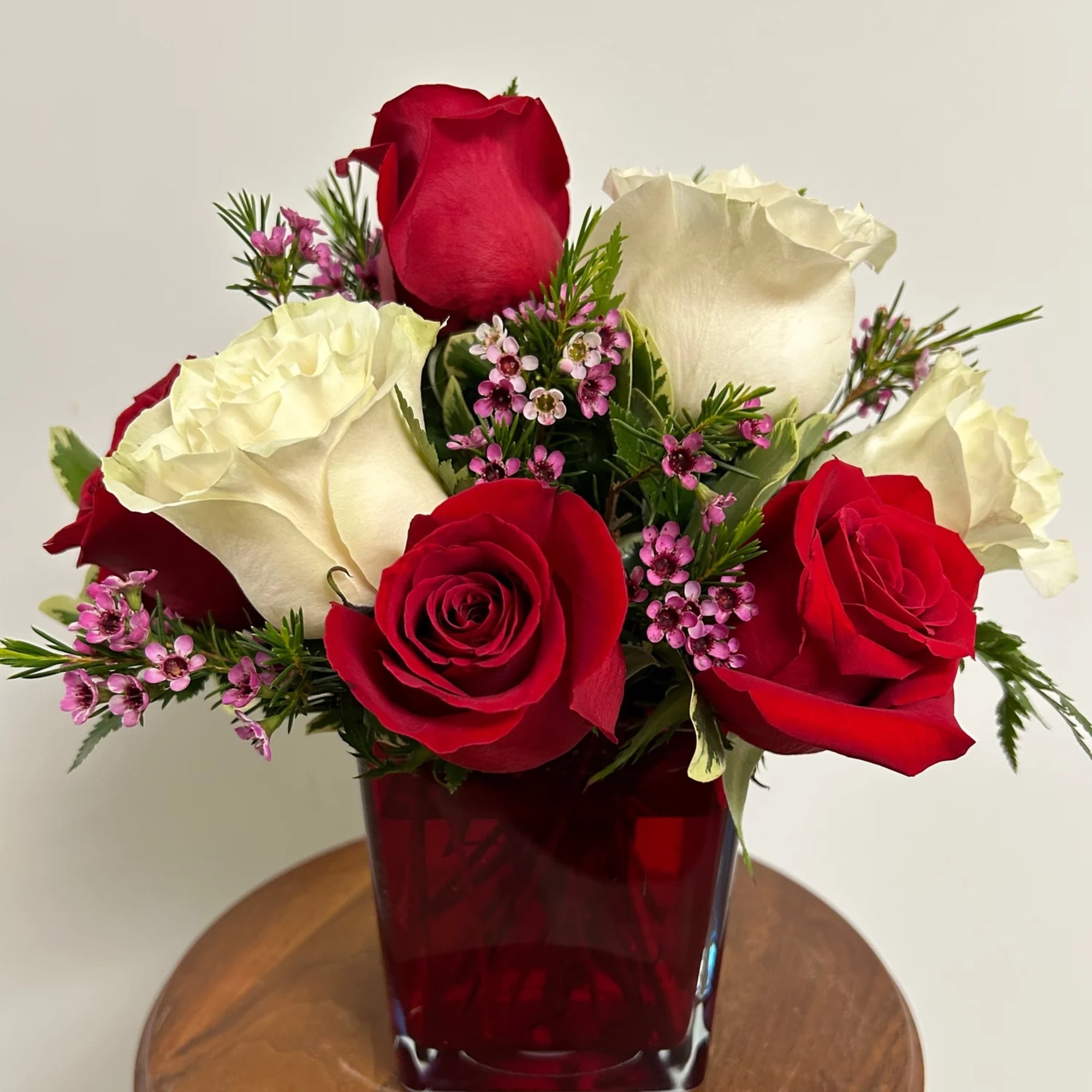 A graceful bouquet of 10 red and white roses with waxflower (or