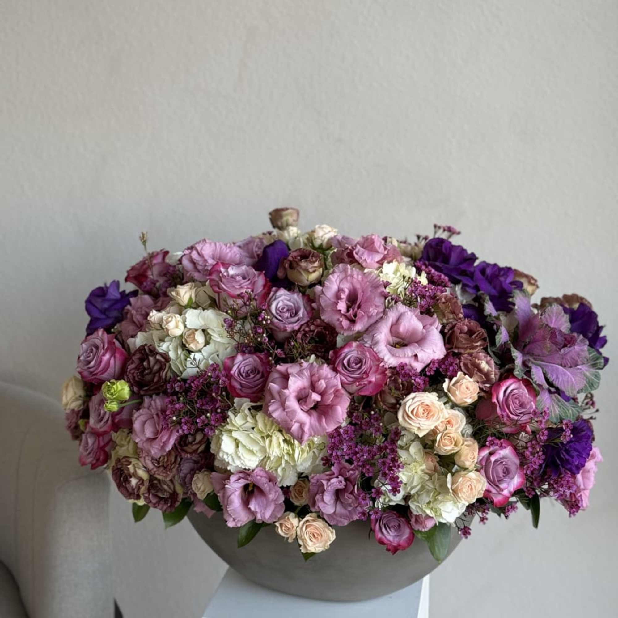 An enchanting ensemble of various purple blooms, elegantly arranged in a clear