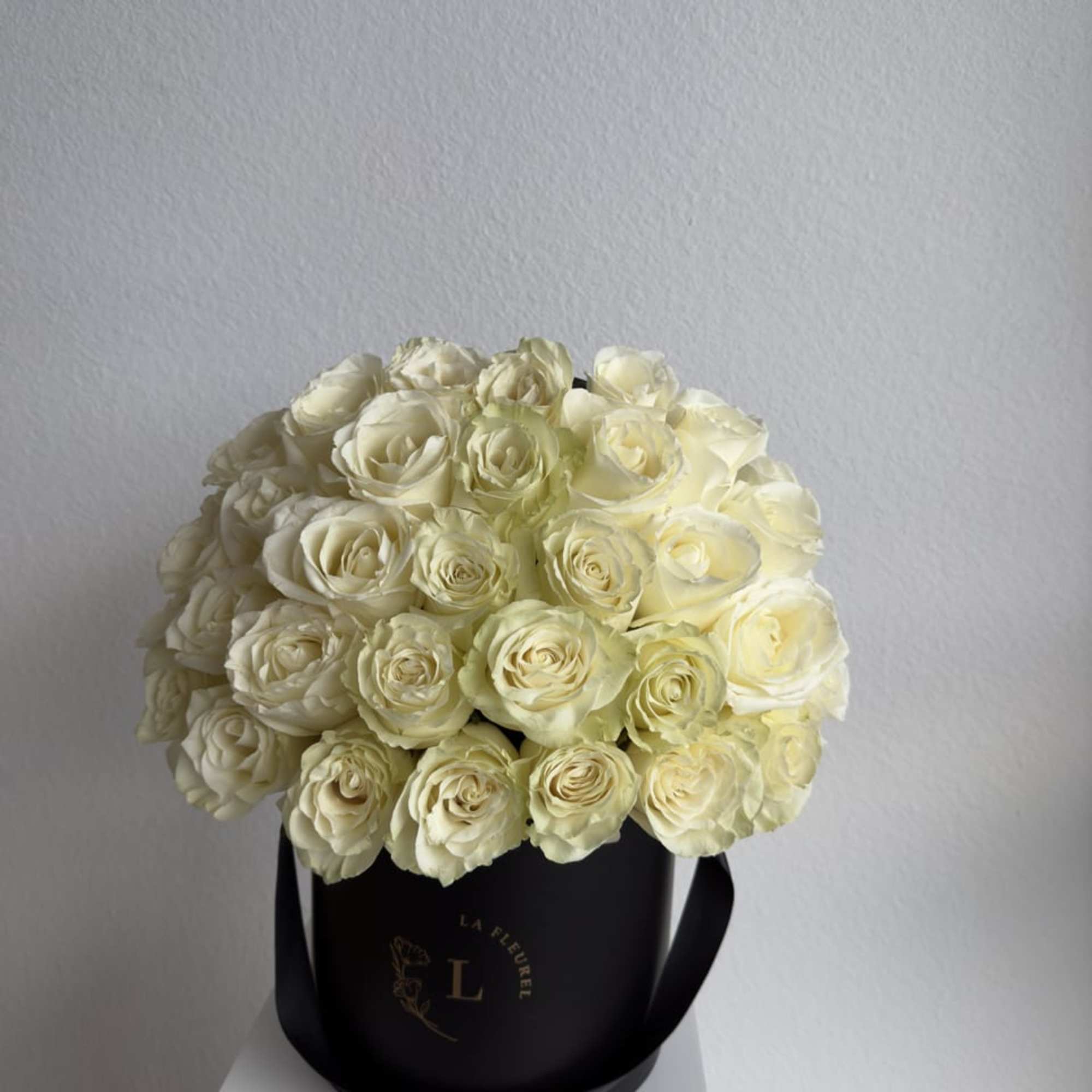 This beautiful arrangement filled with white roses and greens to deliver your